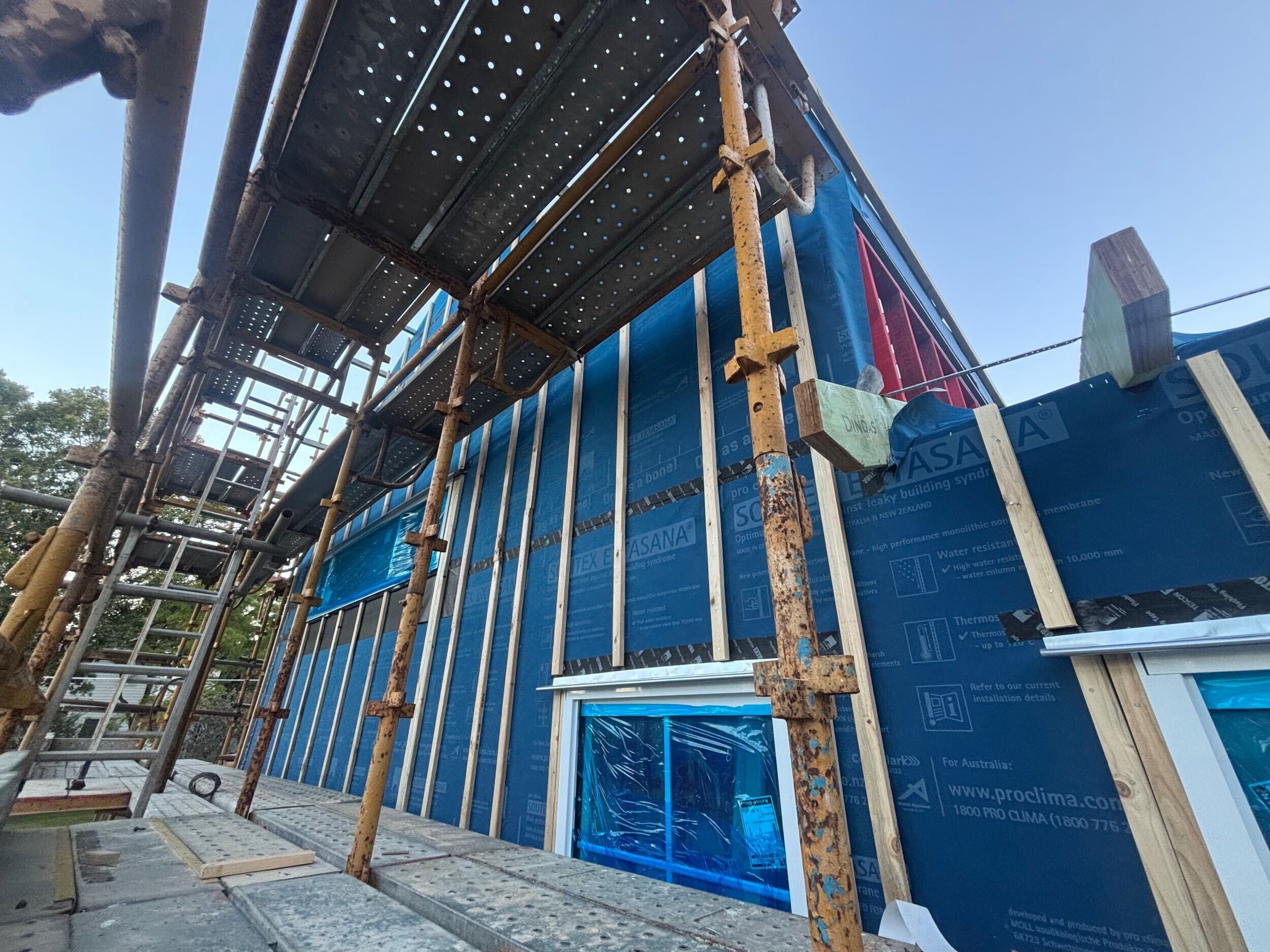 External wall system wrapped in Pro Clima Solitex weatherproofing with scaffolding installed, timber battens fixed vertically for upcoming cladding on Project 135 Grange.