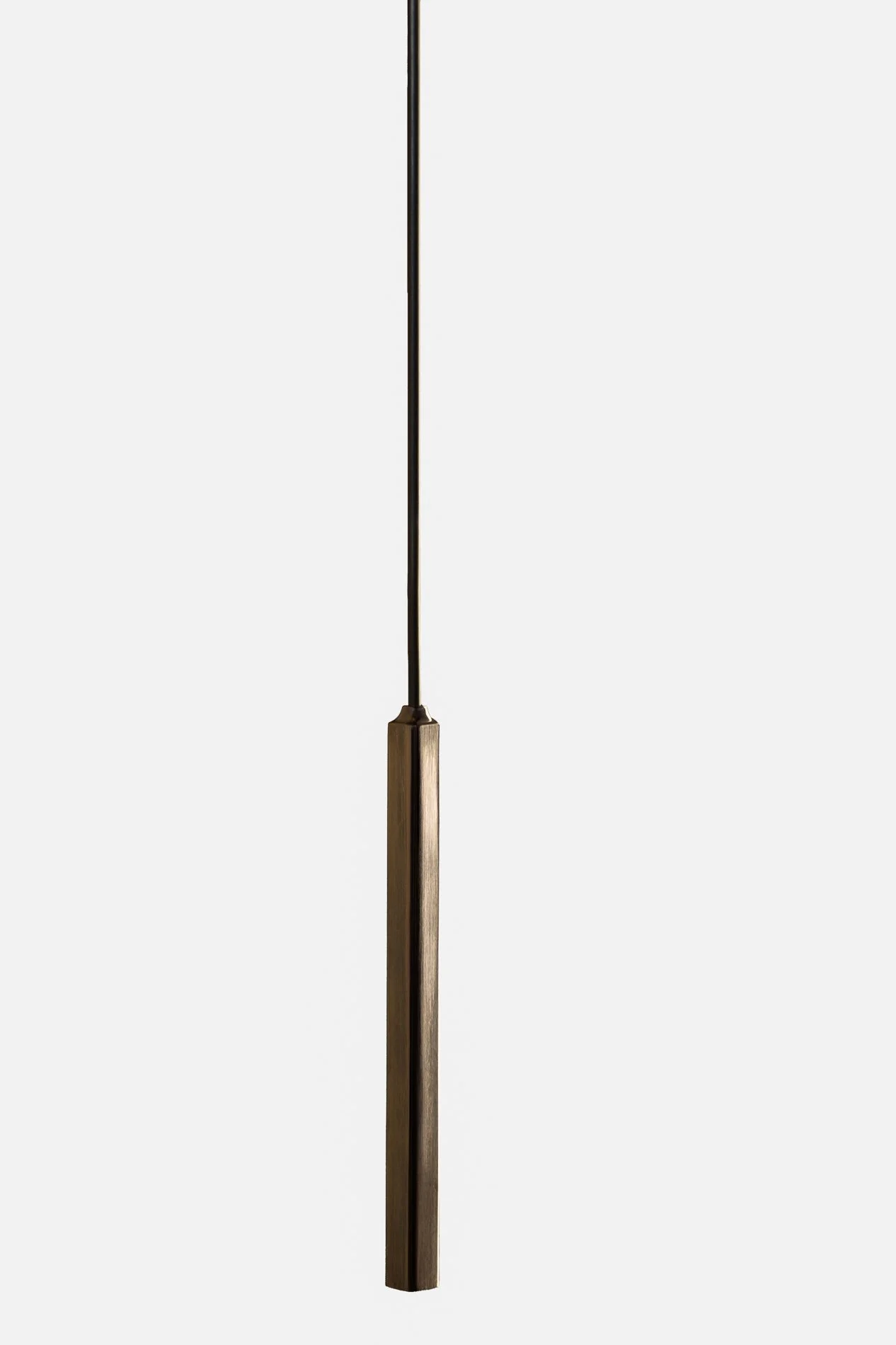 A minimalistic pendant light with a brass finish hanging from a black cord