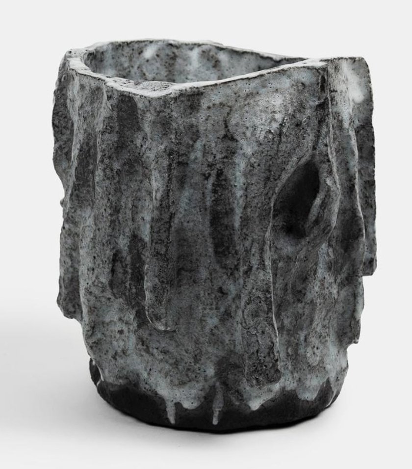 A ceramic sculpture resembling a human face with prominent features and a hollow eye socket.