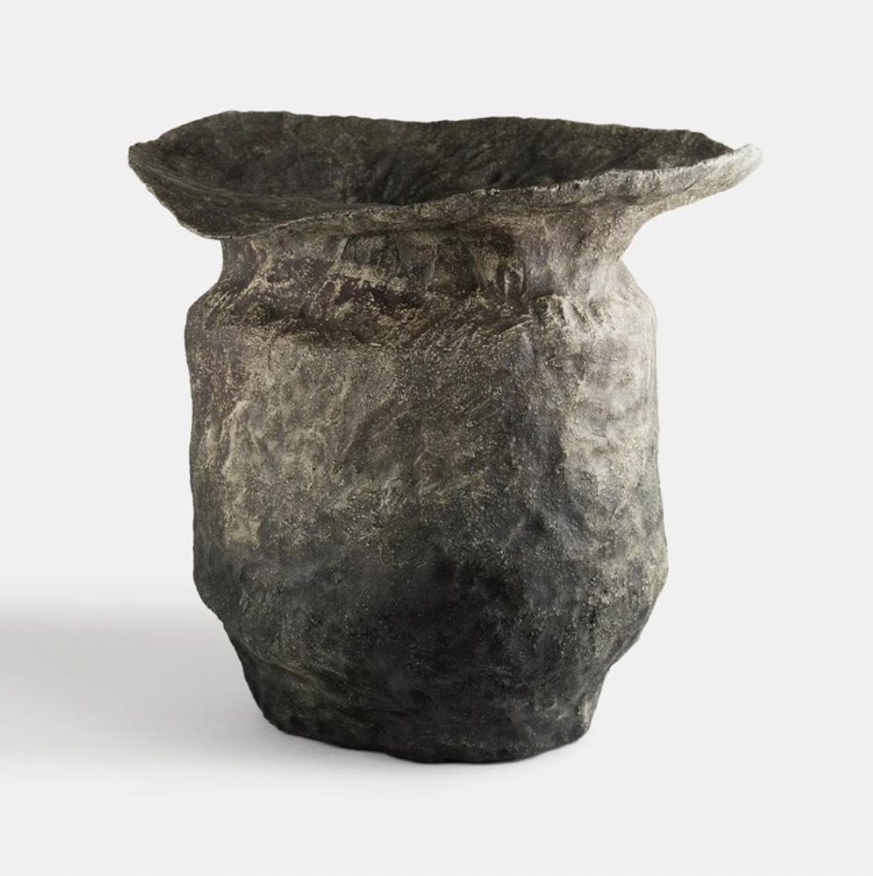 Ancient ceramic vase with a wide, flared rim and a rounded base.