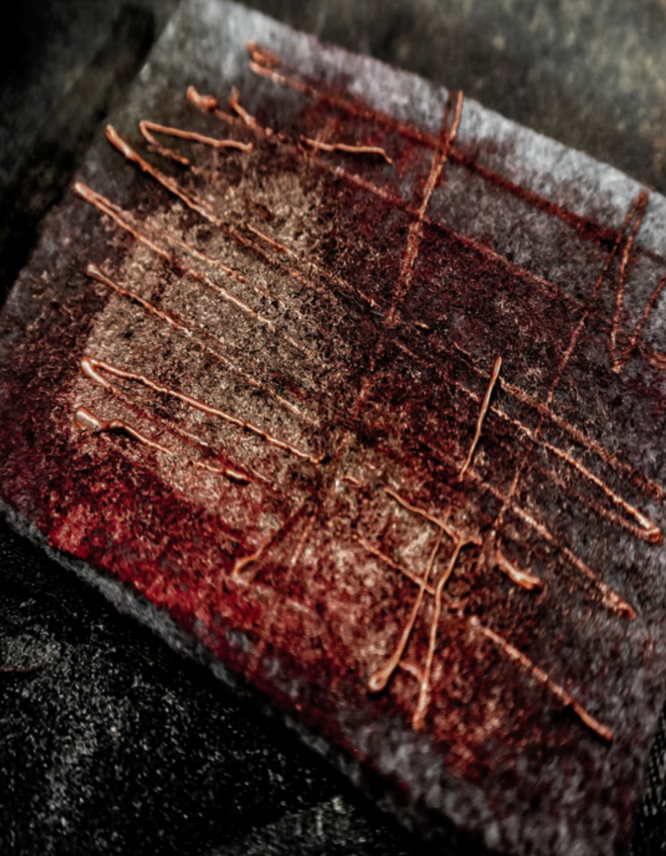 Close-up of a rusty, textured metal surface with scratch marks and brownish-red streaks.