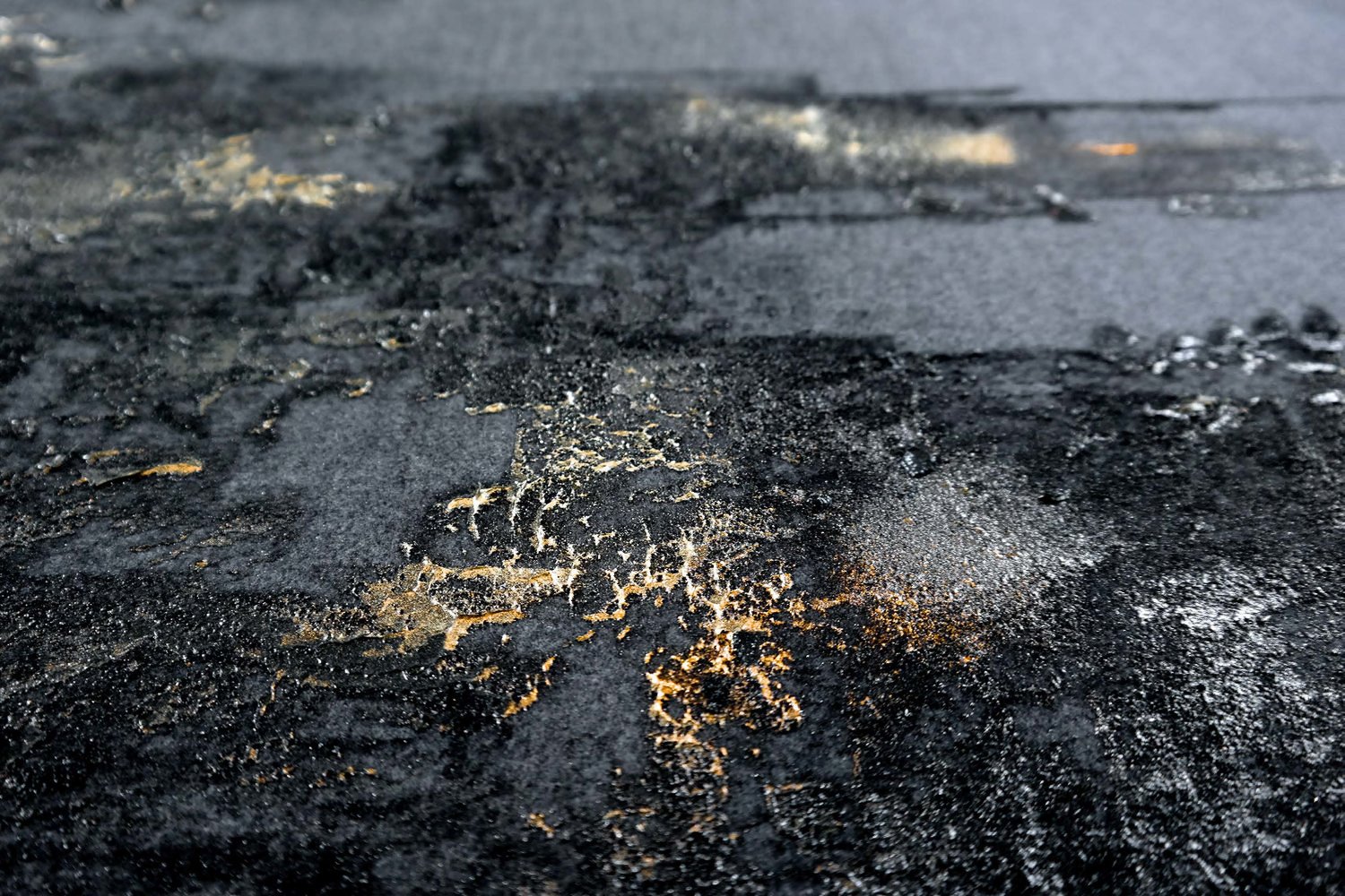 Close-up of a blackened and charred surface with cracks and burnt residue.