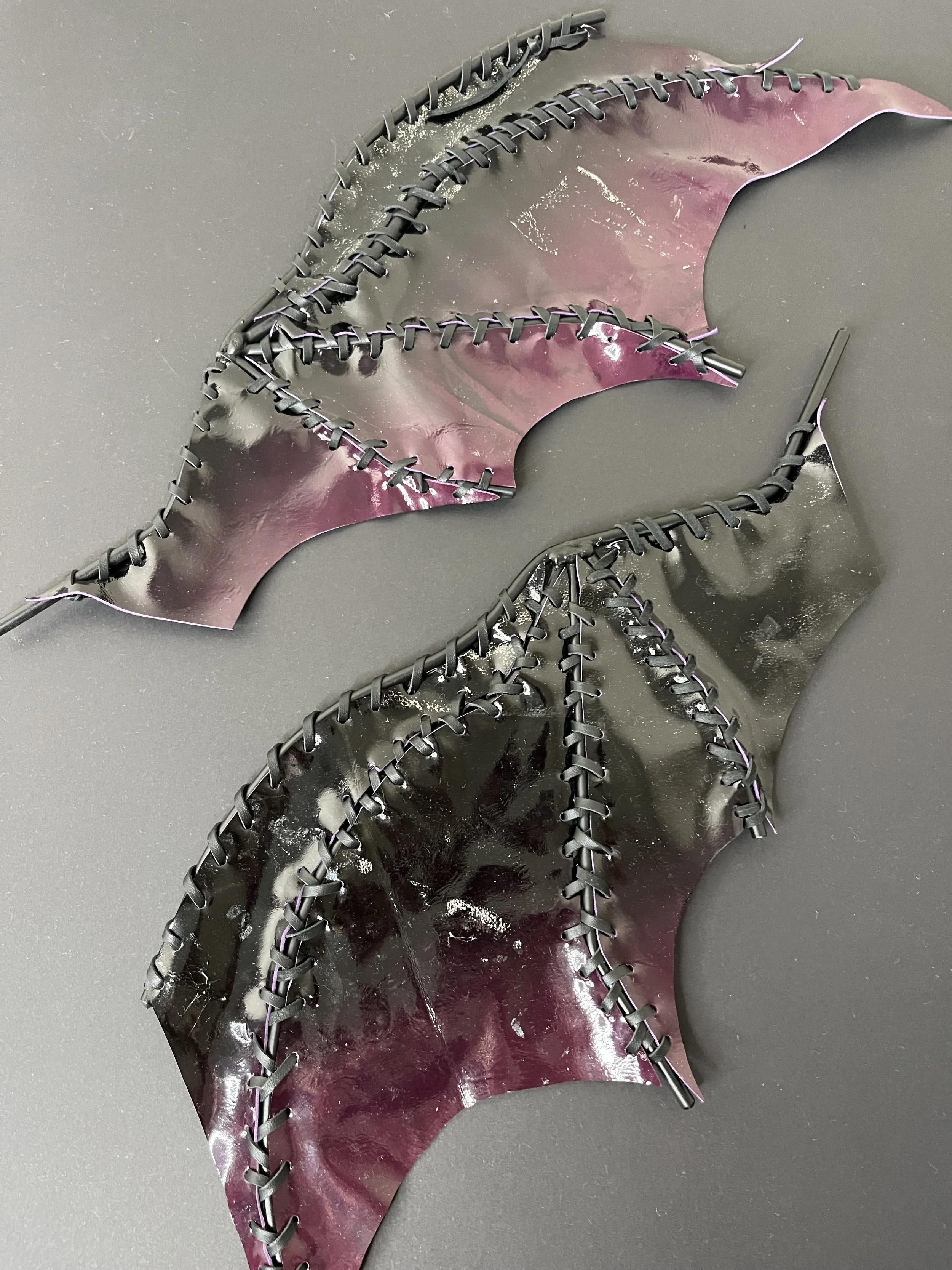 “Nightshade Wings” (2026), welded steel, paint, leather, 40(w)  x 19(l)  x 1(d)cm per wing