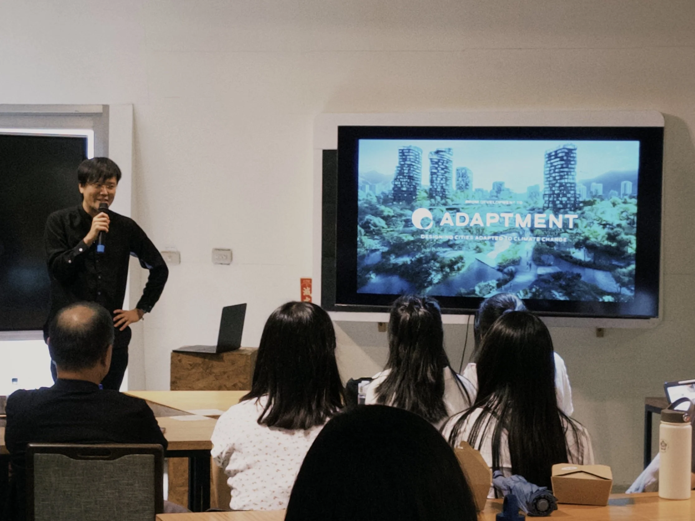 Eisuke Tachikawa presenting the ADAPTMENT framework during a talk on evolutionary thinking and design.