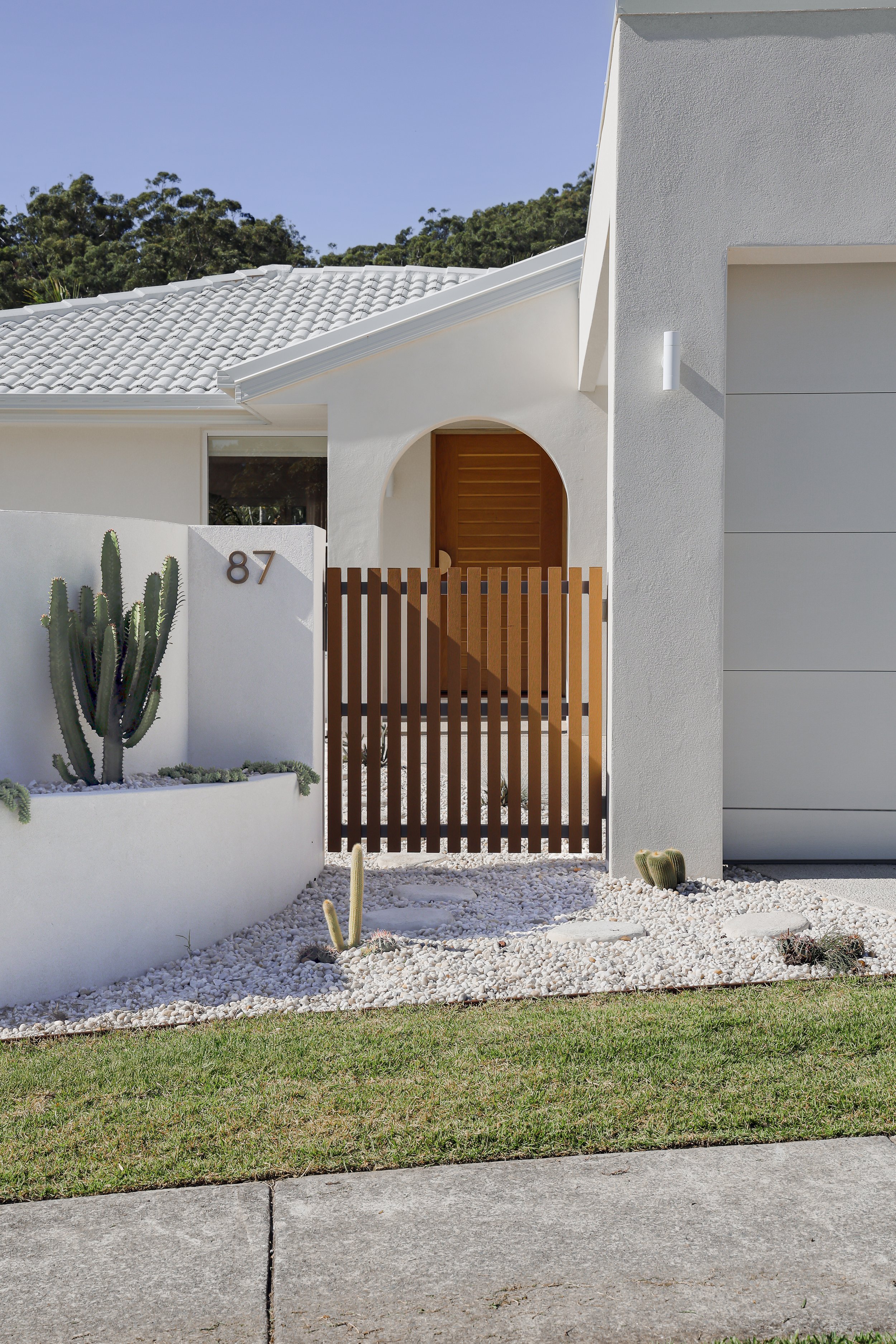 White rendered exterior with wood gate