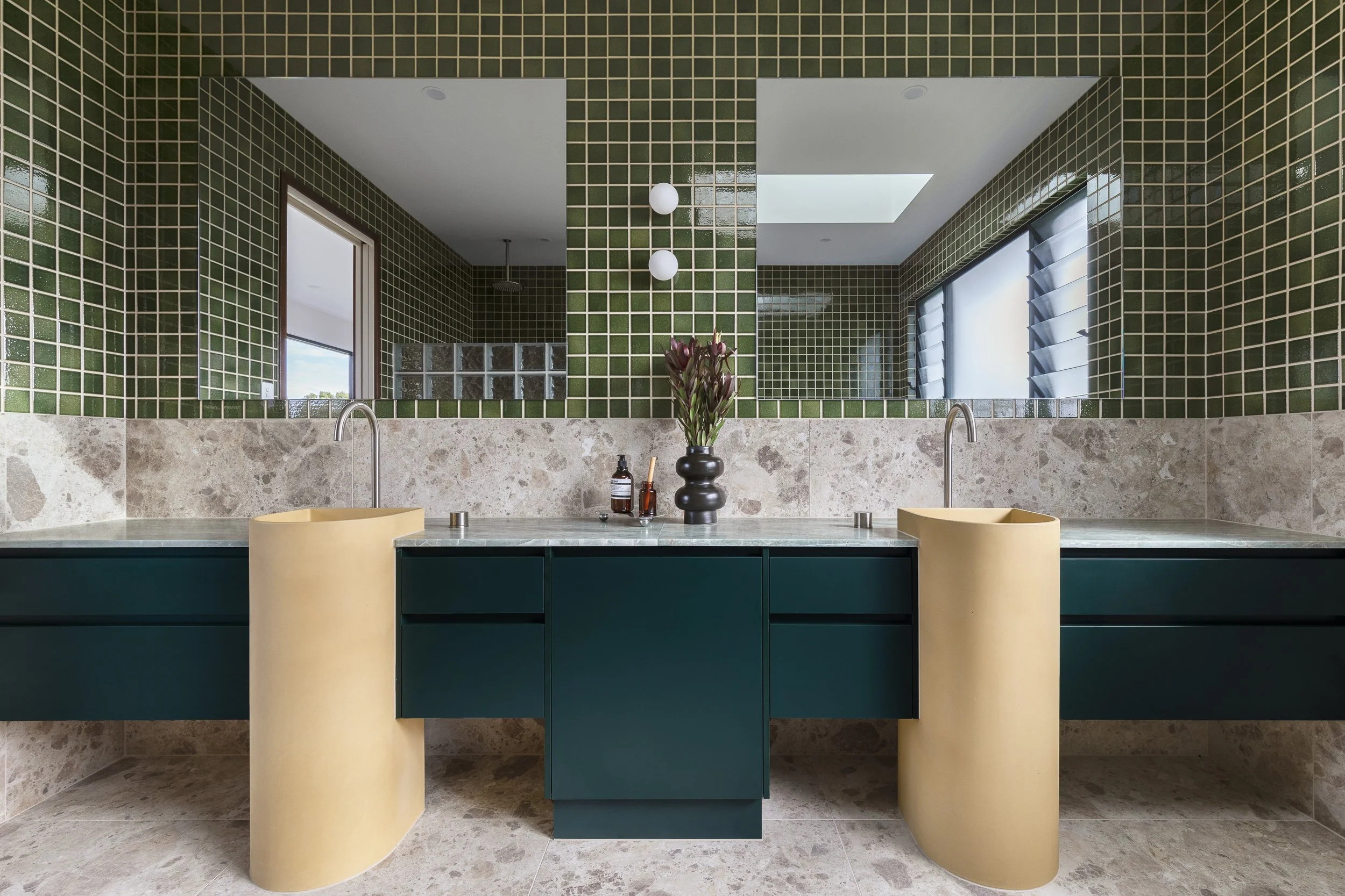 green tiled double vanity bathroom teal cabinetry and yellow mustard pedestal basins