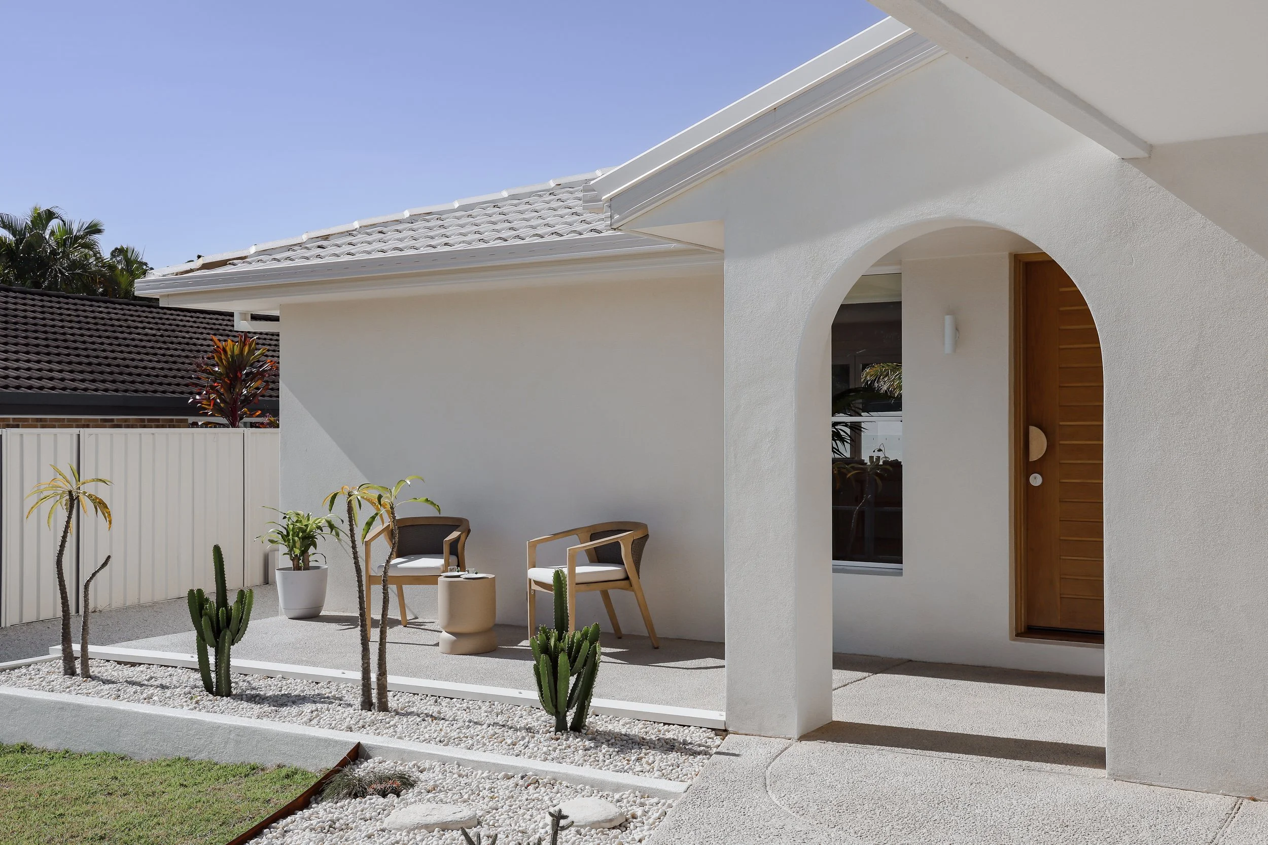 White rendered exterior with arch entry way