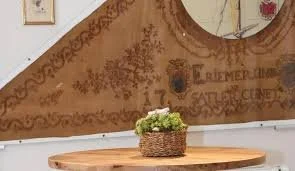 Runder Spiegel an der Wand, dekorative Wandkunst, Holztisch mit Topf voller Blumen.