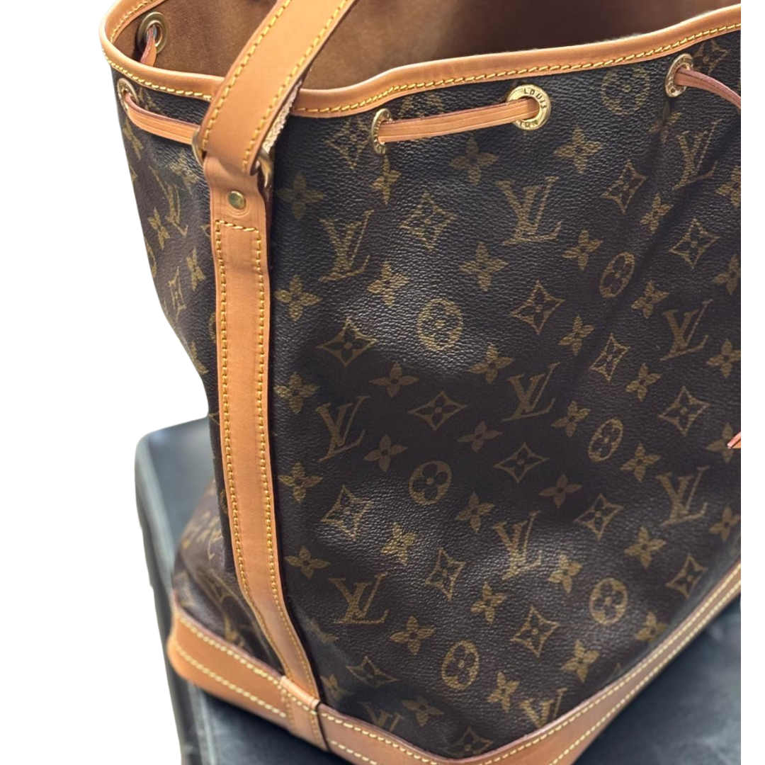 Louis Vuitton Tasche mit Monogramm-Muster auf einer schwarzen Oberfläche.