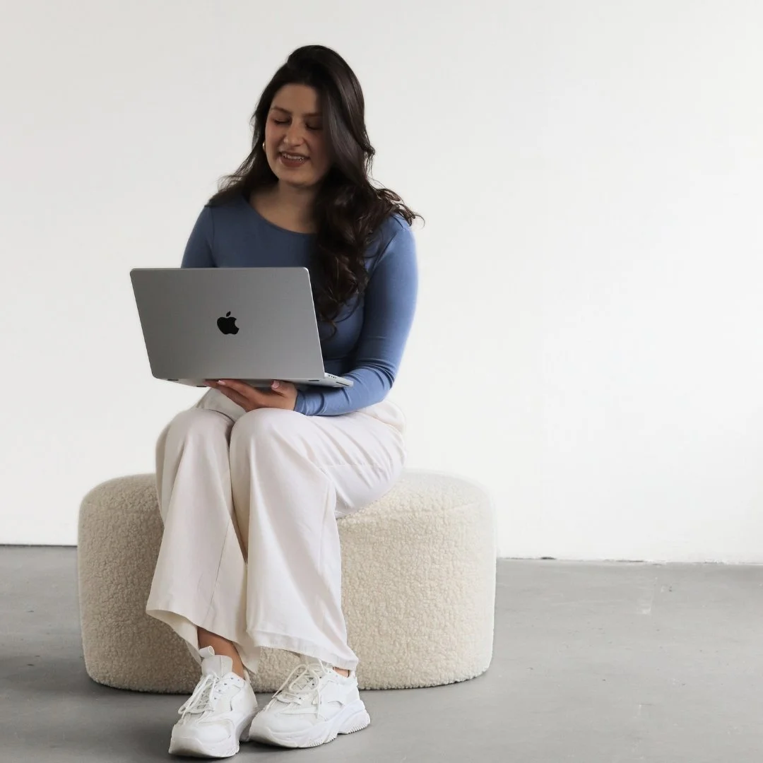 Ease Socials Founder Ivana auf einem Hocker mit Laptop auf em Schoß