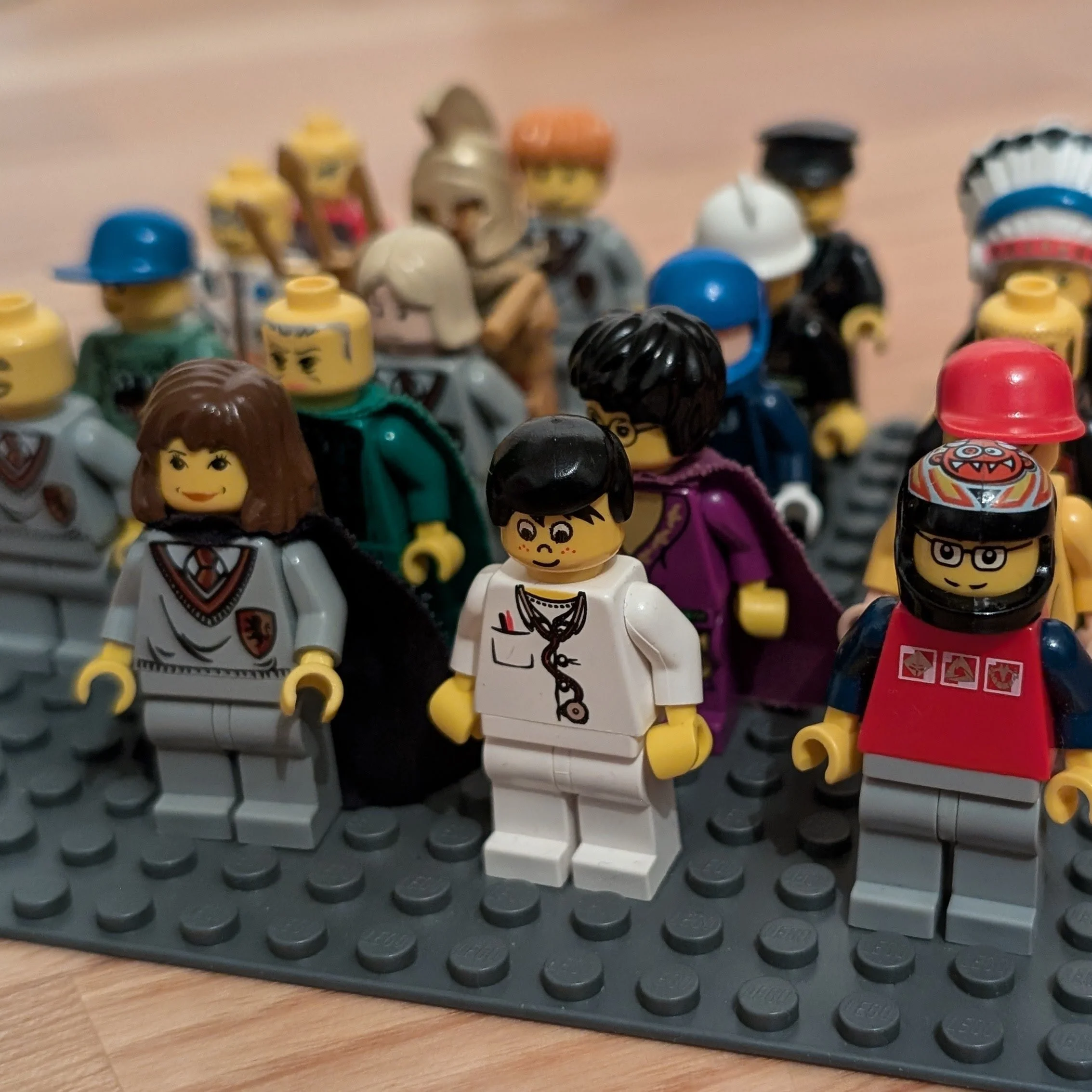 LEGO mini-figures arranged on a baseplate, featuring various characters in diverse outfits and costumes.