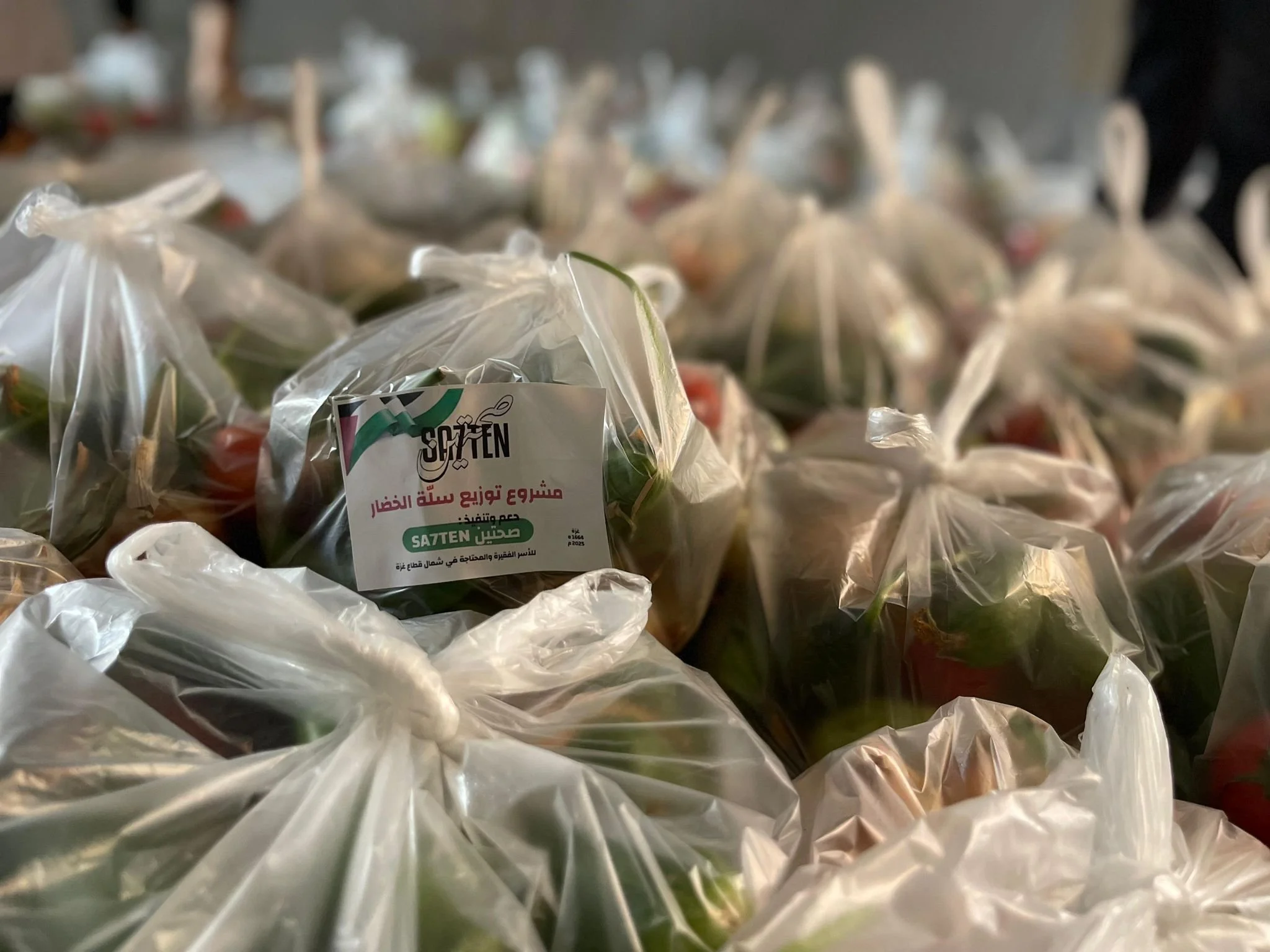 Multiple plastic bags filled with vegetables, labeled with a sticker, on a table.