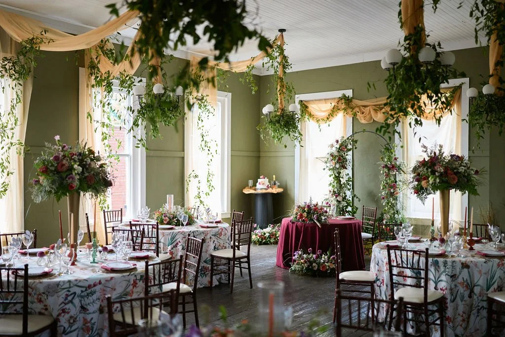 table and chairs with floral linens, floral arch, and cake table in The Yorkville Enquirer