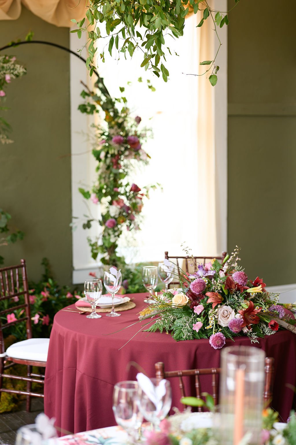 table with floral archway in the background