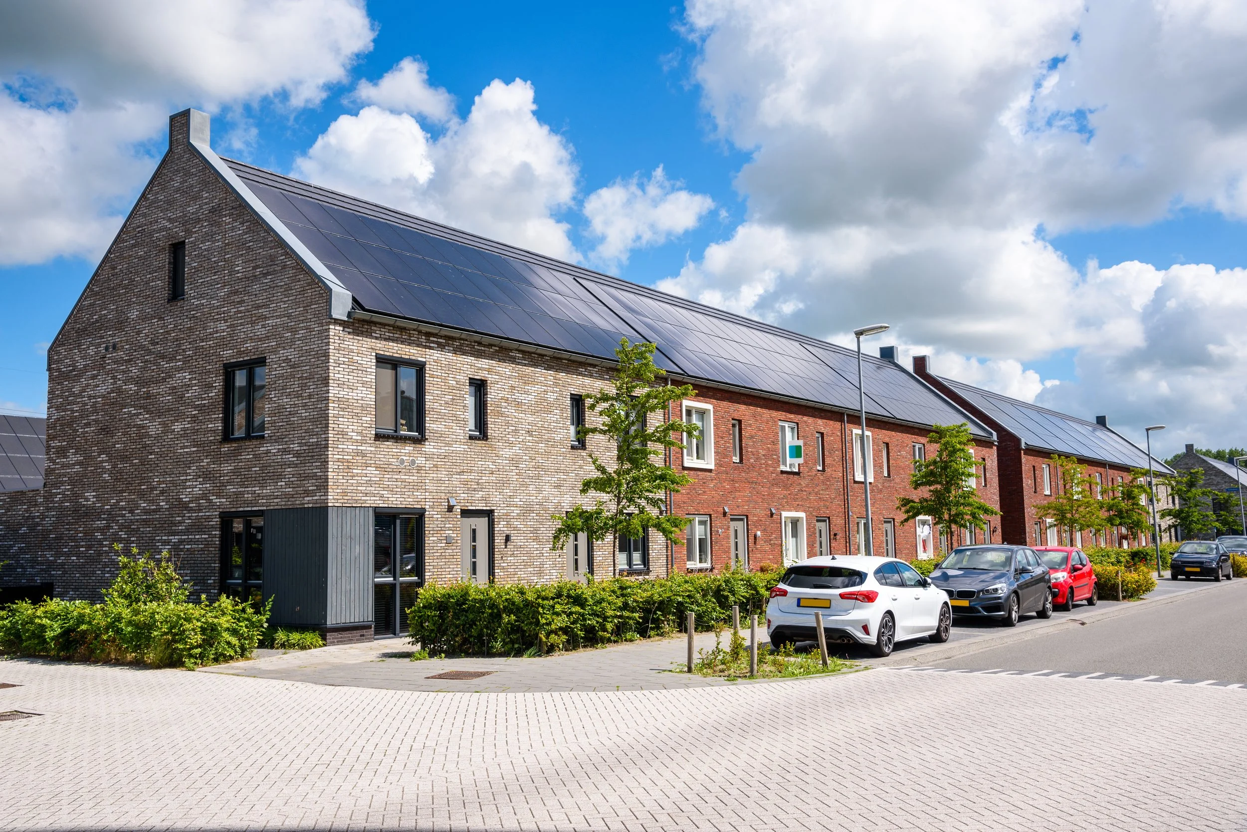 Solar panel installation on modern homes in North Wales, showing residential rooftop solar PV systems generating renewable energy.
