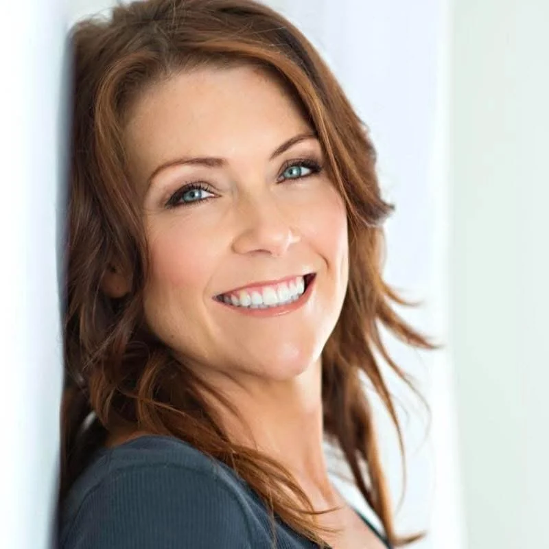 Here is an image of Mood Edit & Co. Owner Gina Woelfel. She is smiling and has blue eyes and red hair