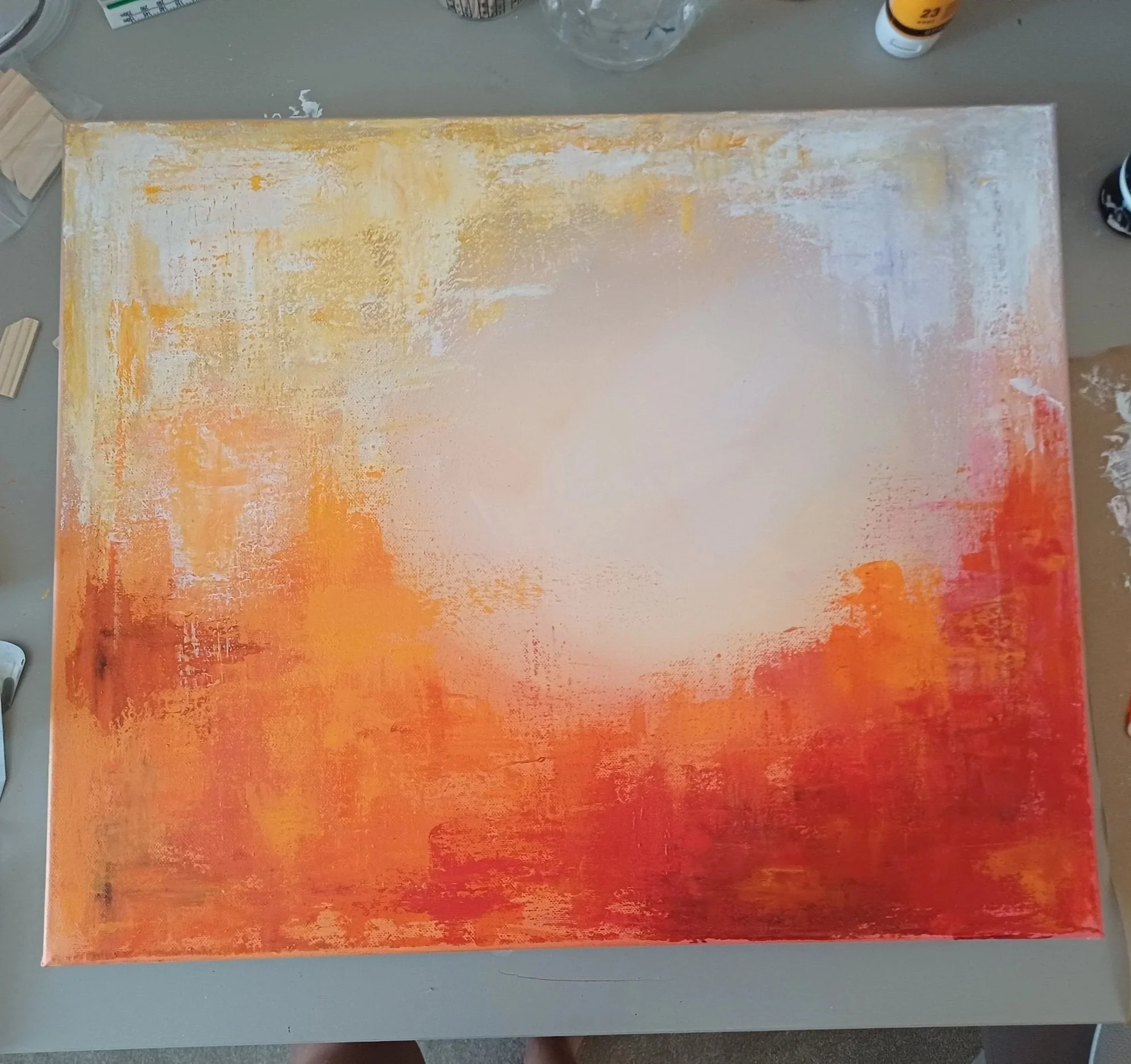  I then added different non-diluted paints onto the canvas with a palette knife using the base layer colours as a guide. To do this I added paint to a palette knife and gently dragged it across the canvas. 