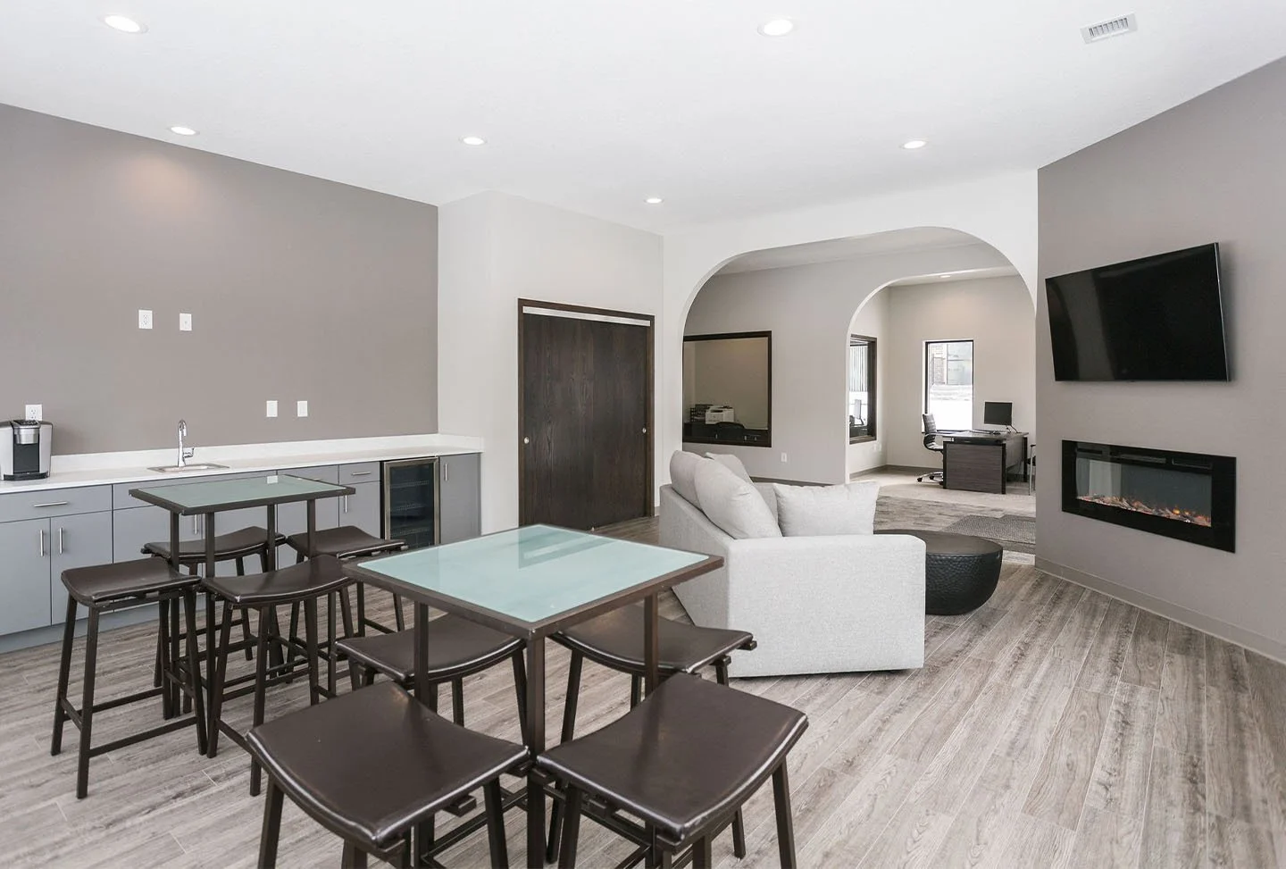 Open-concept clubhouse with seating, community kitchen, and fireplace.