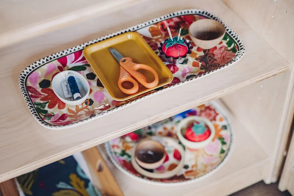 Neatly arranged Montessori materials on wooden trays and shelves