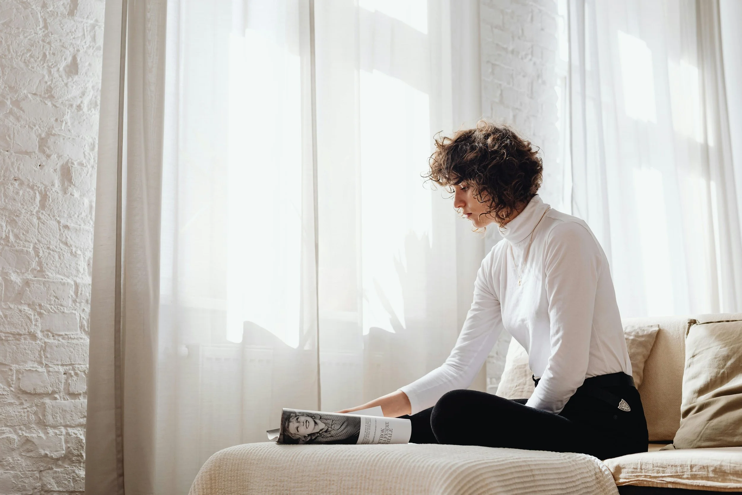 Woman reading and reflecting in natural light, representing therapy for anxiety, burnout, and overthinking in Charlotte NC and PSYPACT states