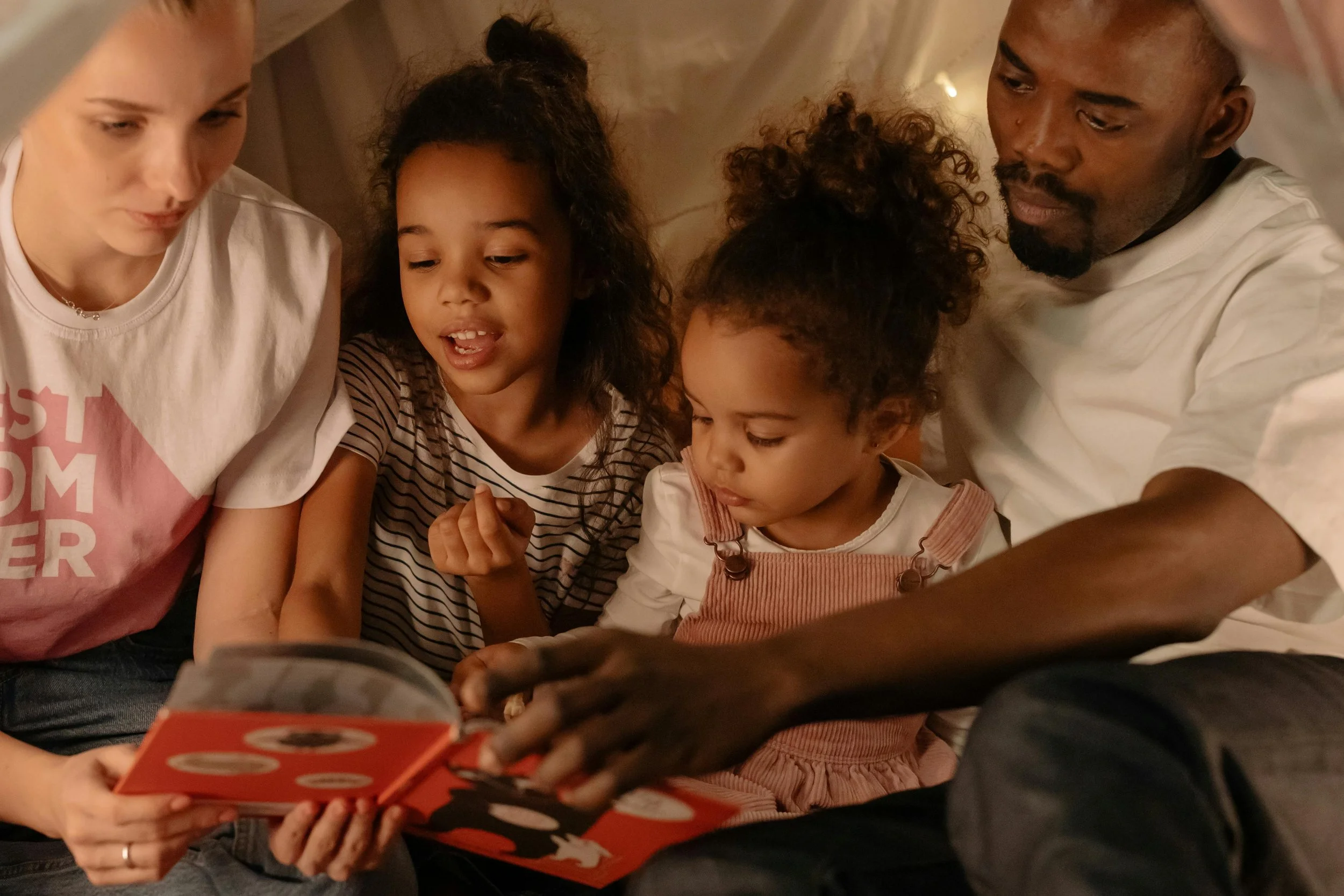 Parents and children snuggling during the holidays reading a story - calm, quiet connection