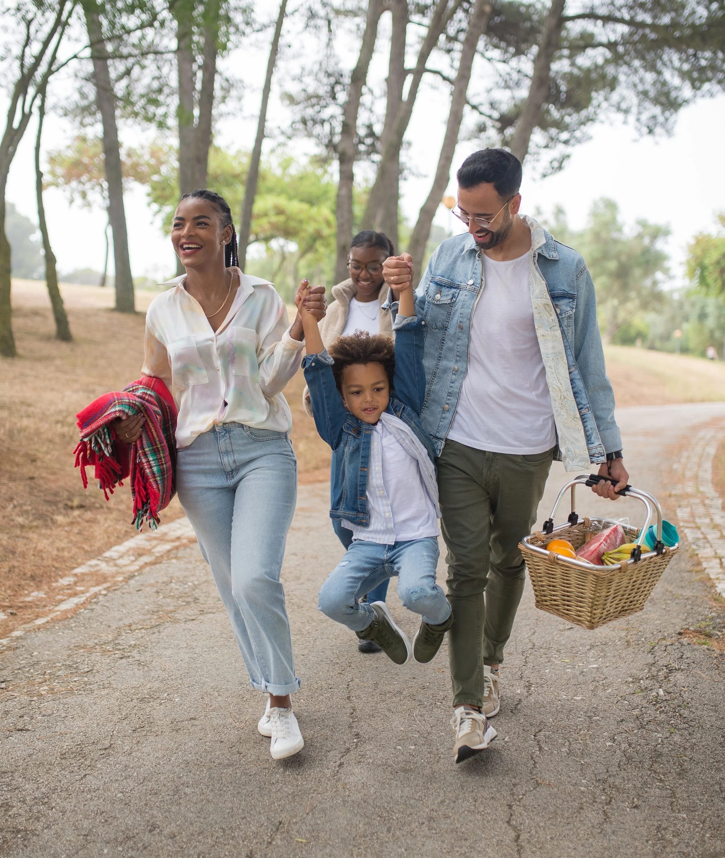 Parents and children enjoying a walk together in a park on a pleasant afternoon.