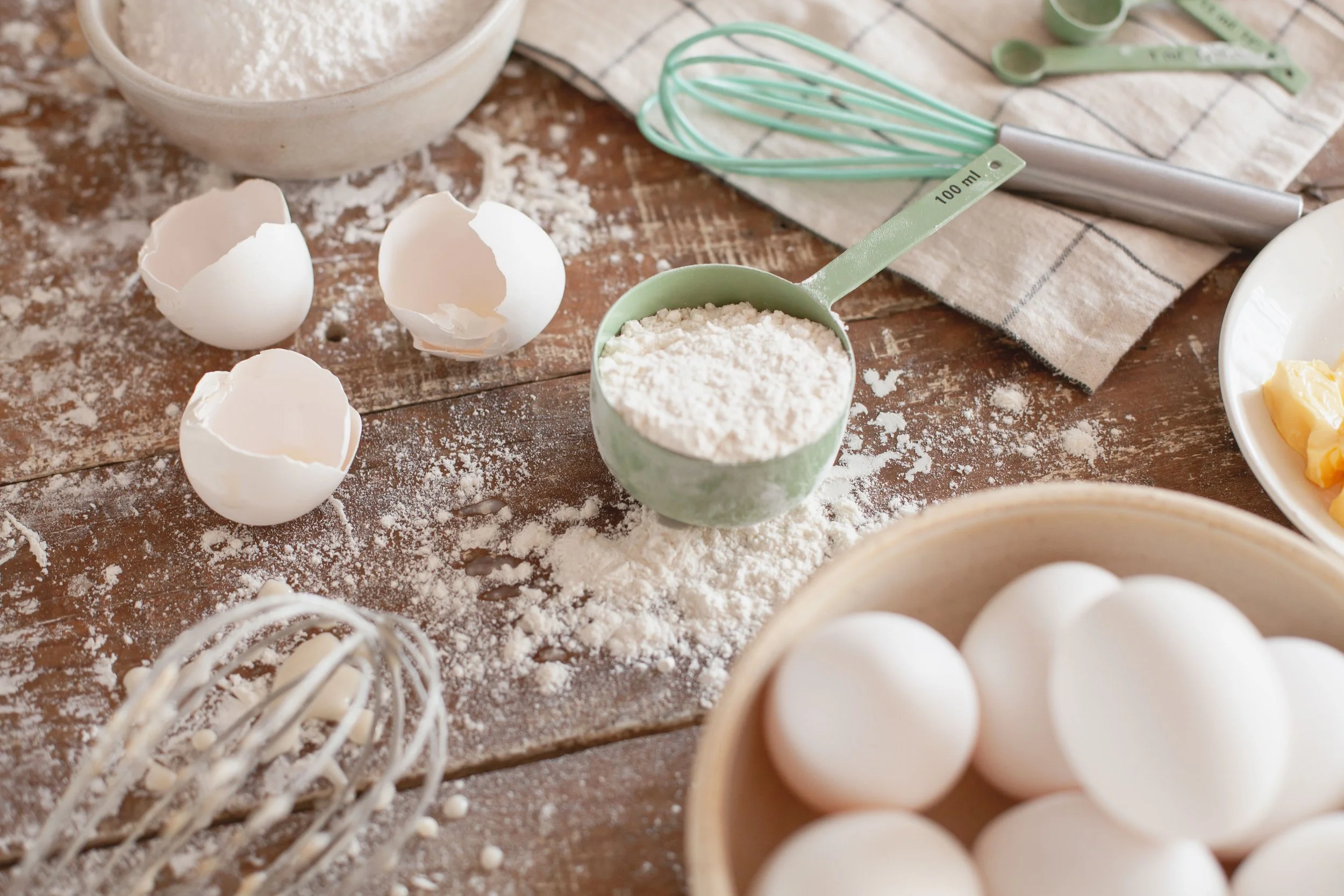Baking ingredients and flour scattered across a kitchen table