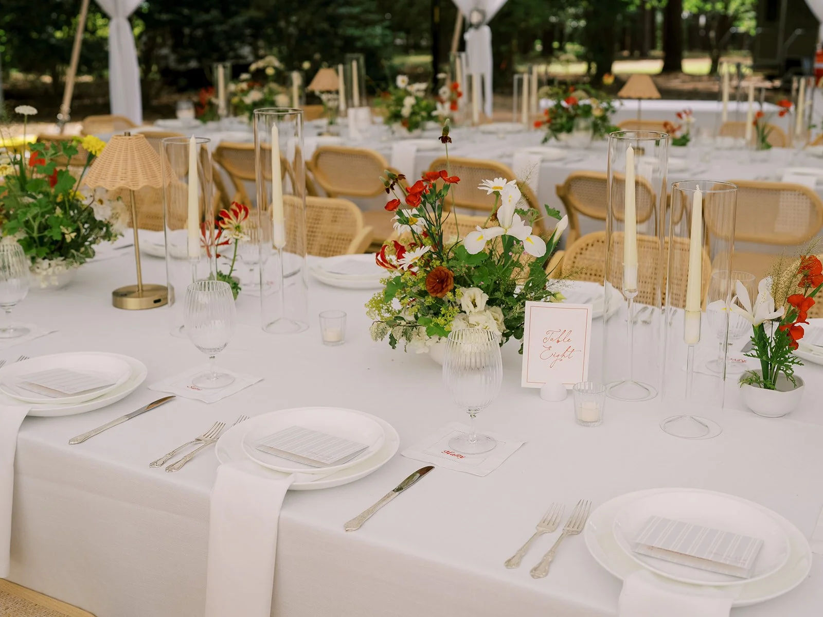 Coastal-inspired intimate wedding tablescape featuring organic wild centerpieces, woven rattan chairs, minimalist place settings, and Table Eight stationery by Carolyn Touchette Events in Pinehurst, NC