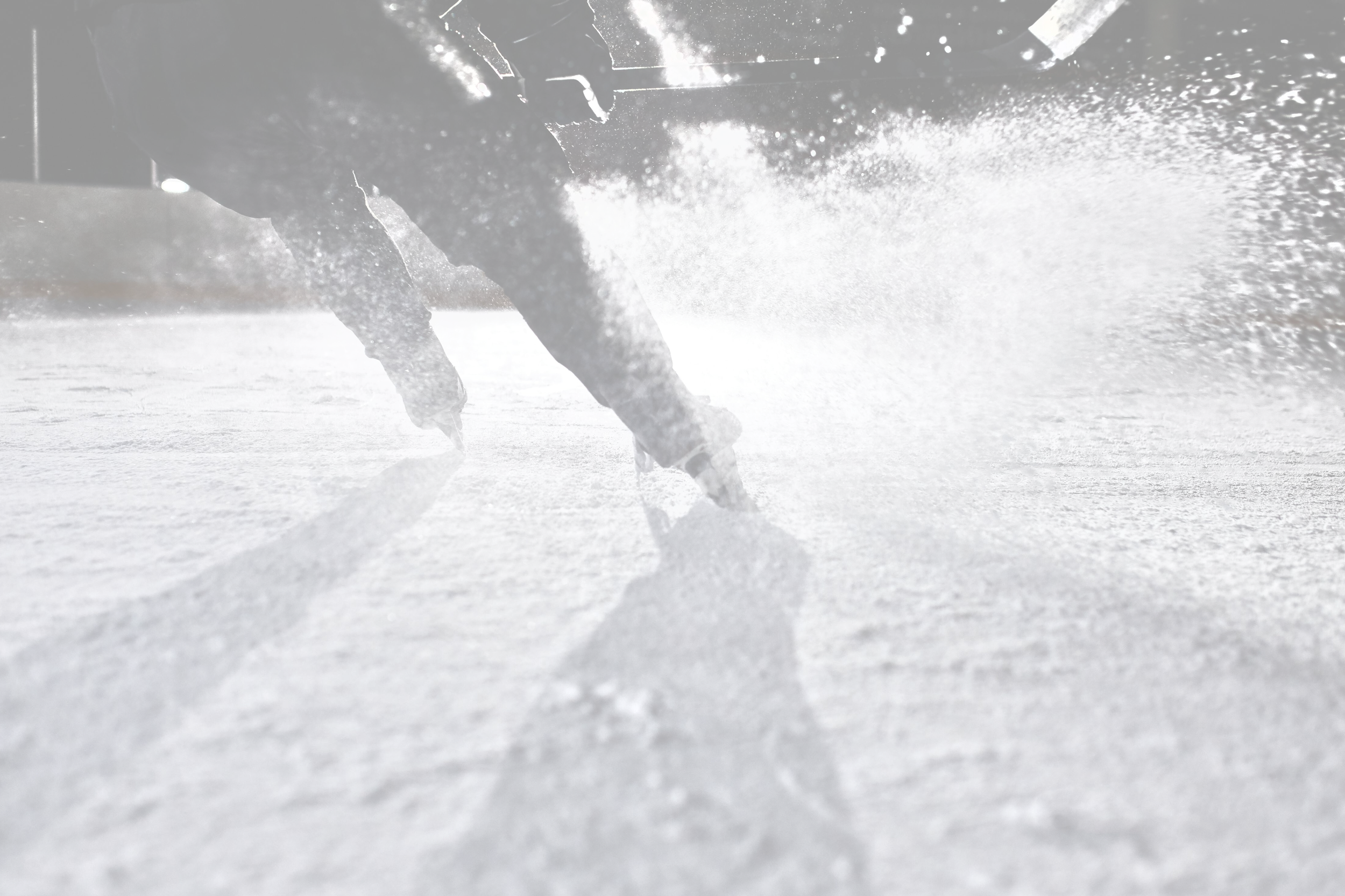 Hockey player on ice shooting puck with spray of ice