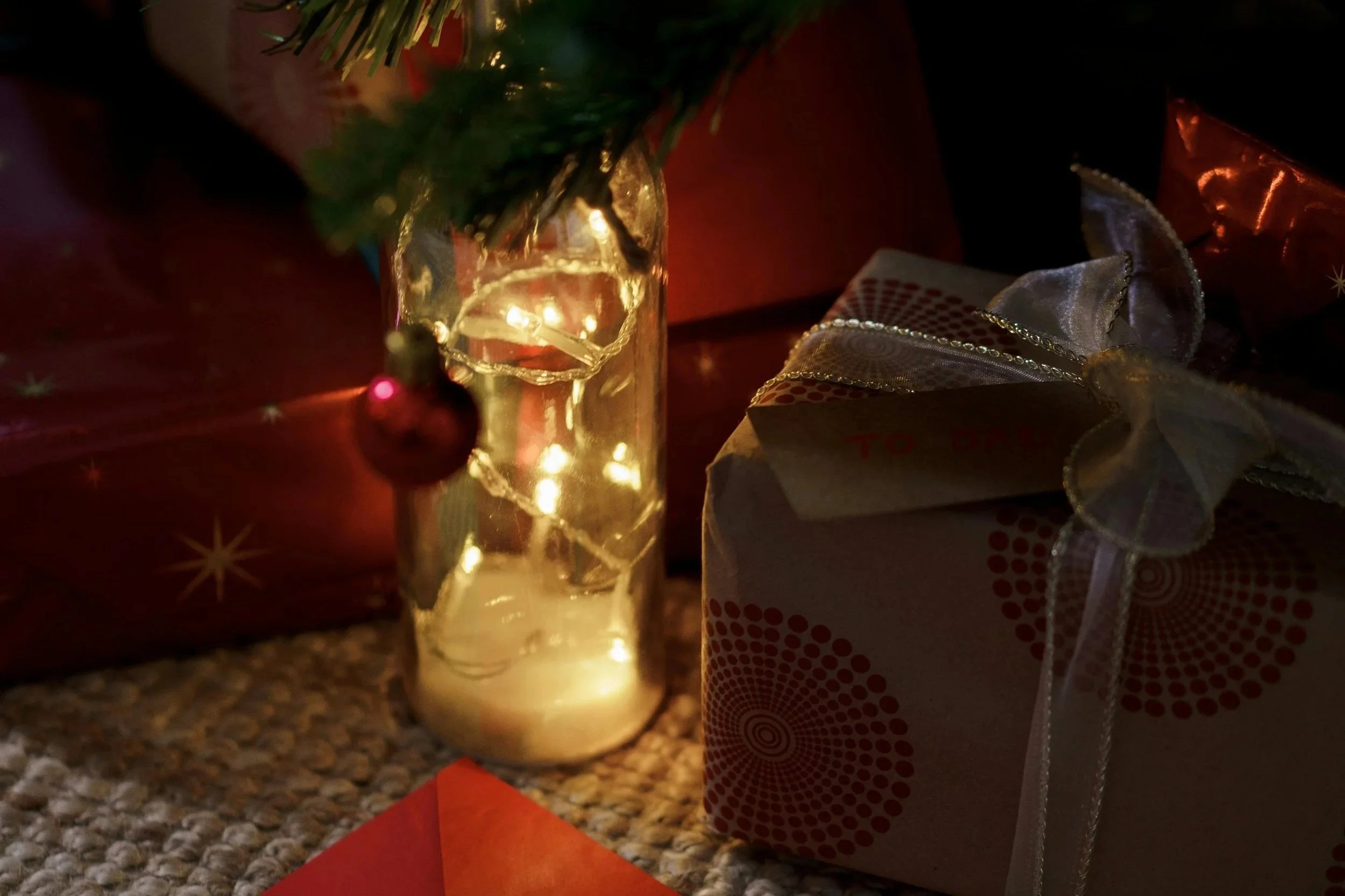 Softly lit presents under a Christmas tree