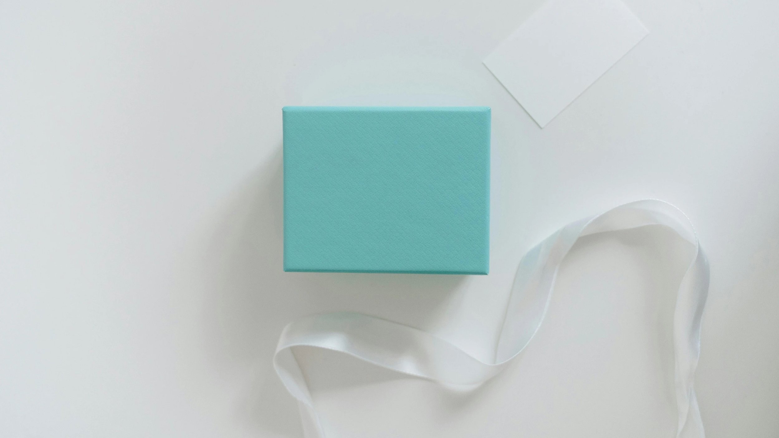 Flat lay with blue jewellery box and white ribbon