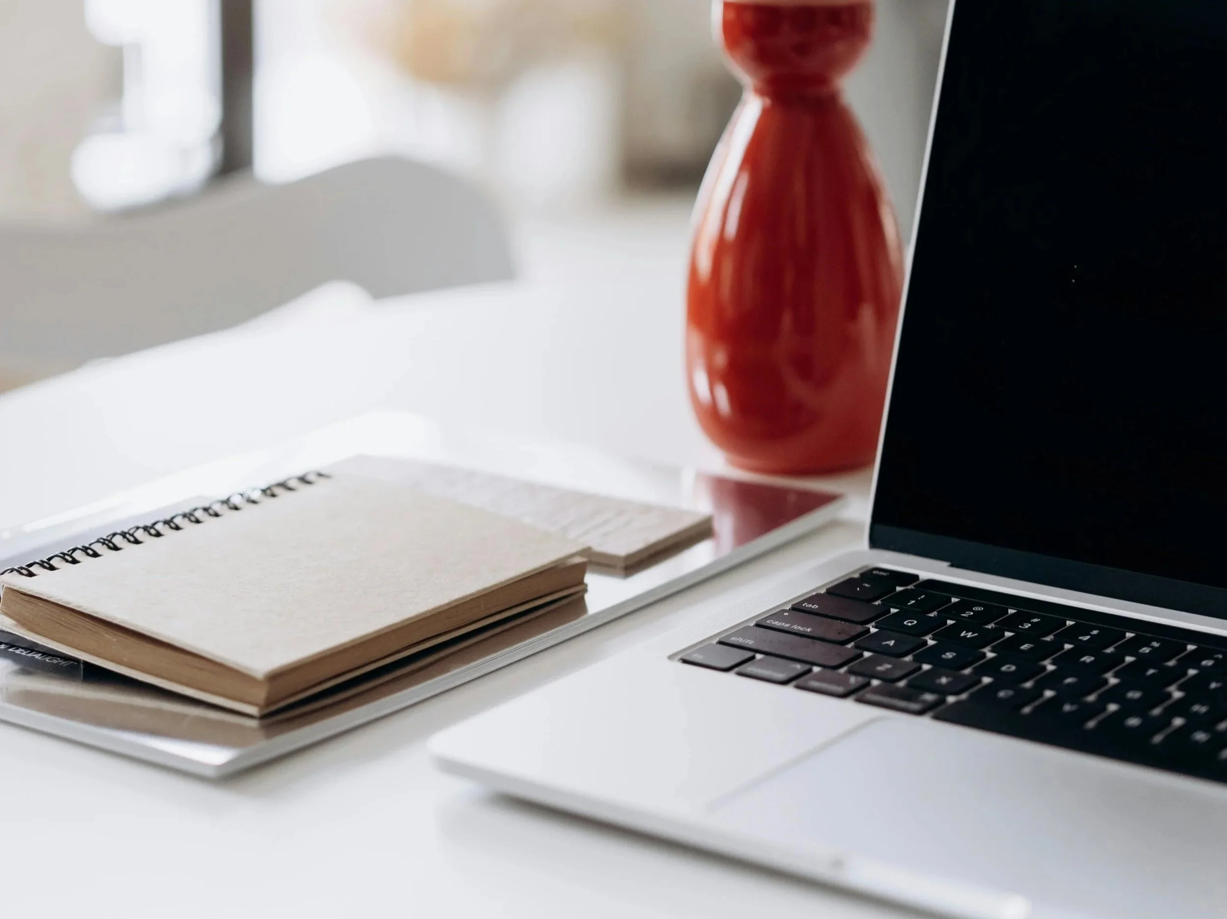 Close up of desk with laptop and notebook