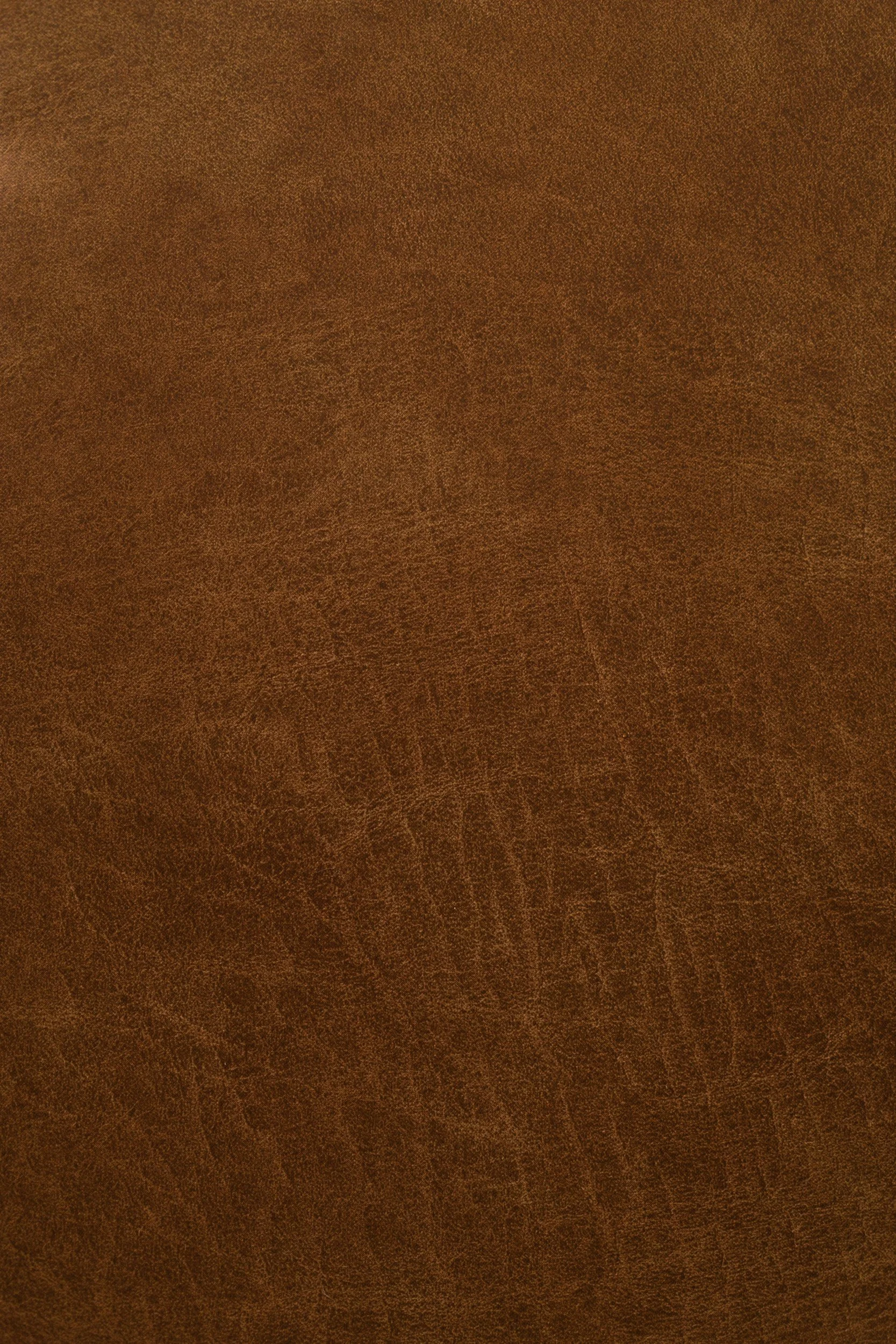 Close-up view of a brown leather surface with visible texture and grain.