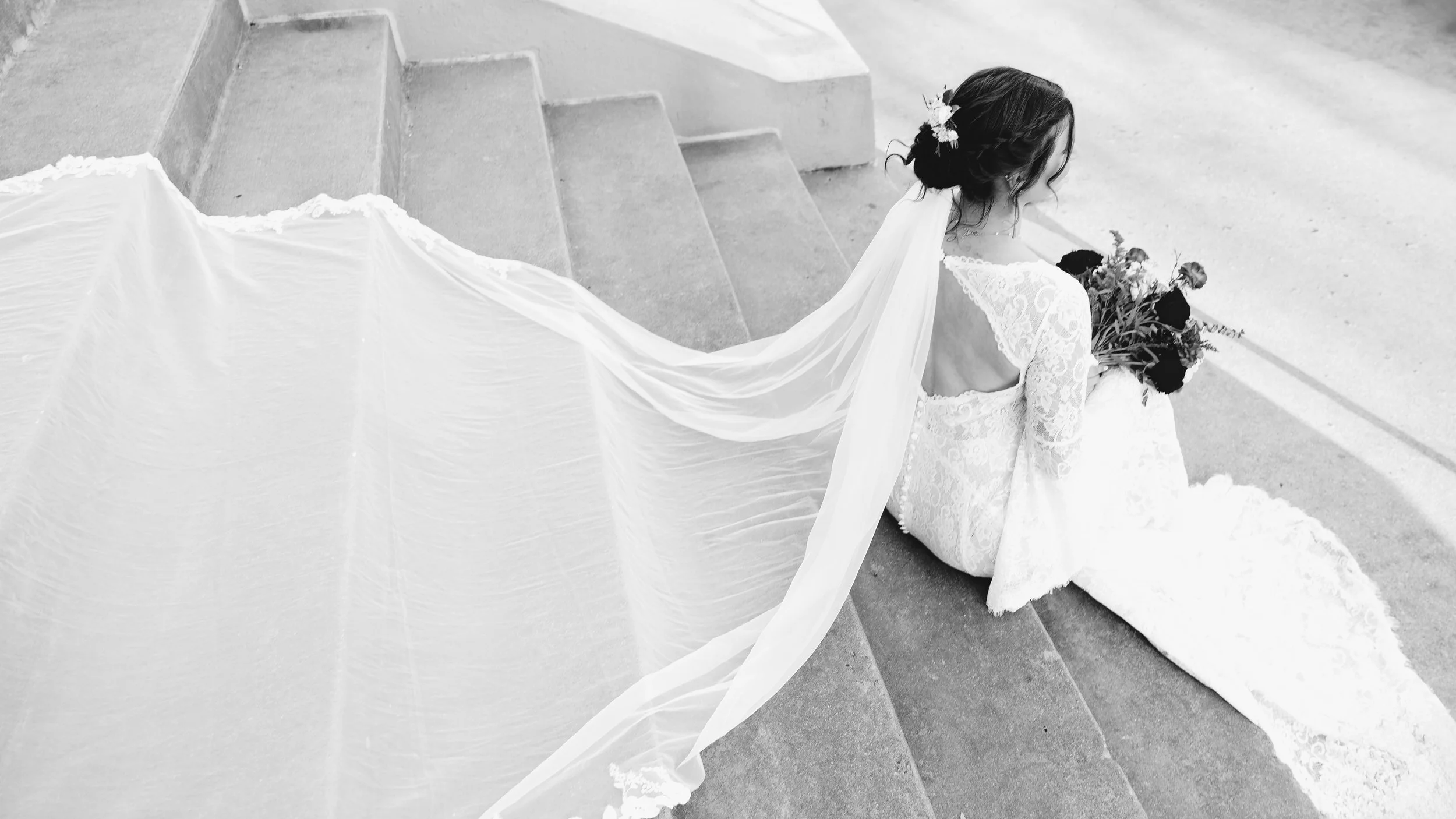 A wooden wall clock showing the time as 4:16, a white floor lamp, and a potted plant with large green leaves against a plain white wall.