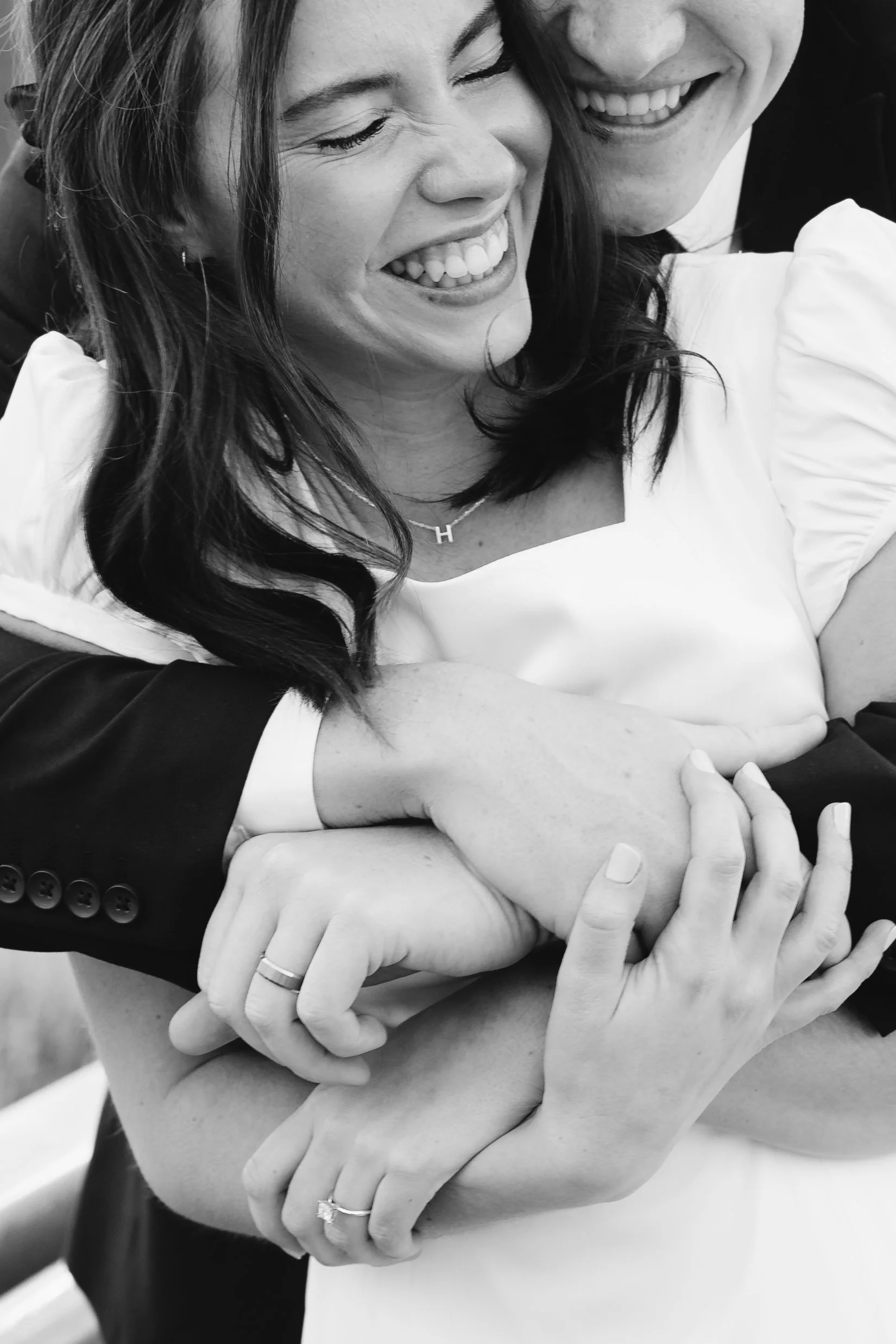 Open notebook with lined pages, white tulips, a lit white candle in a glass holder, and a white surface background.