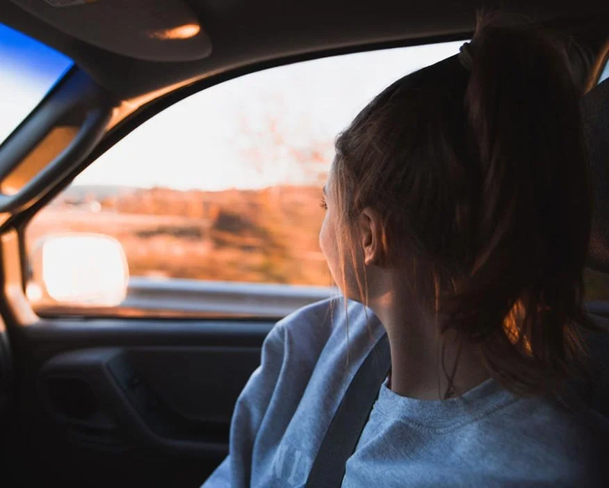 A young girl gazes out the car window, taking in the Northern New Mexico landscape and capturing the spirit of the journey ahead.