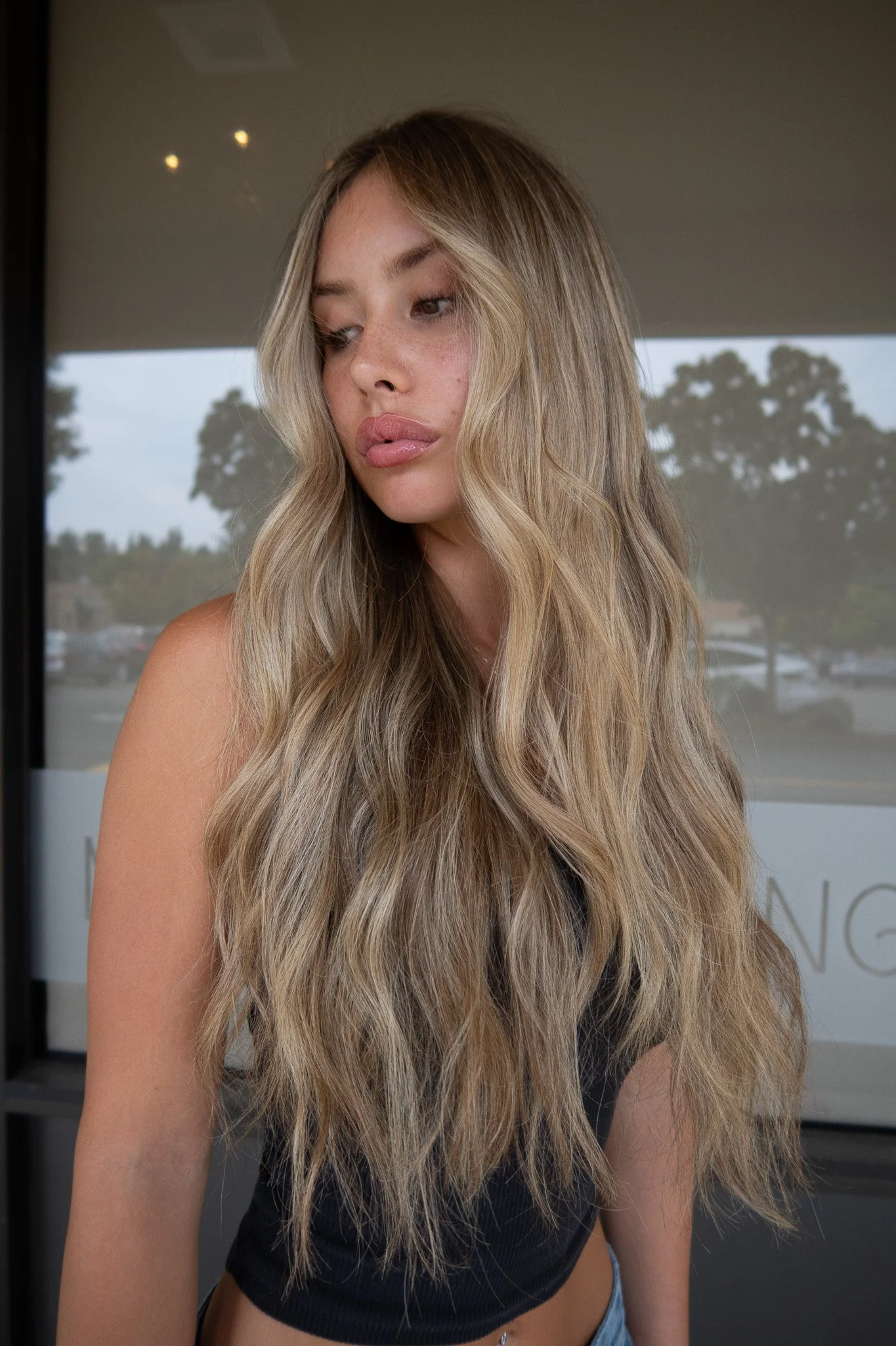 Lived-in blonde balayage with bright face framing highlights and seamless grow-out. Paired with beauty waves by Seattle-area blending specialist Chloe Webster