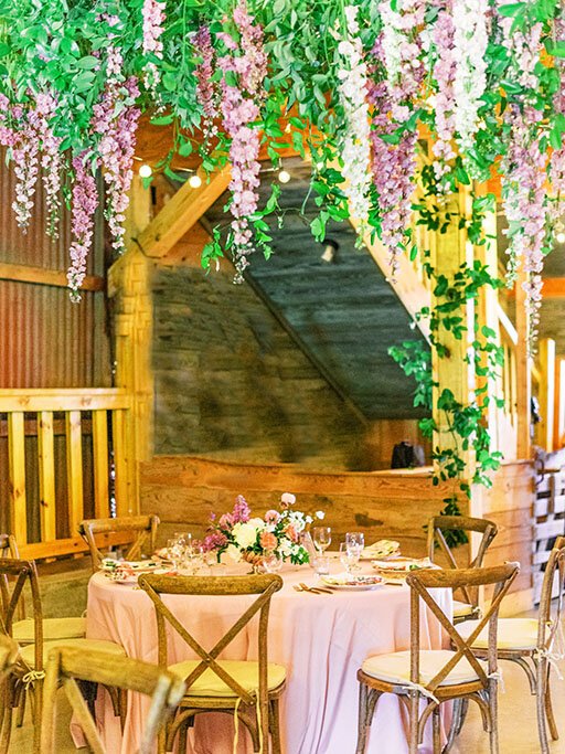 Hanging flowers over reception at Luxury rustic barn wedding