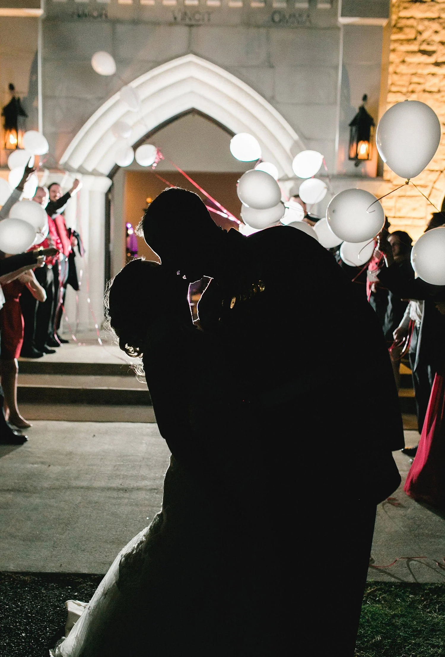 Castle at Rockwall wedding bride and groom kissing with LED balloons in the background