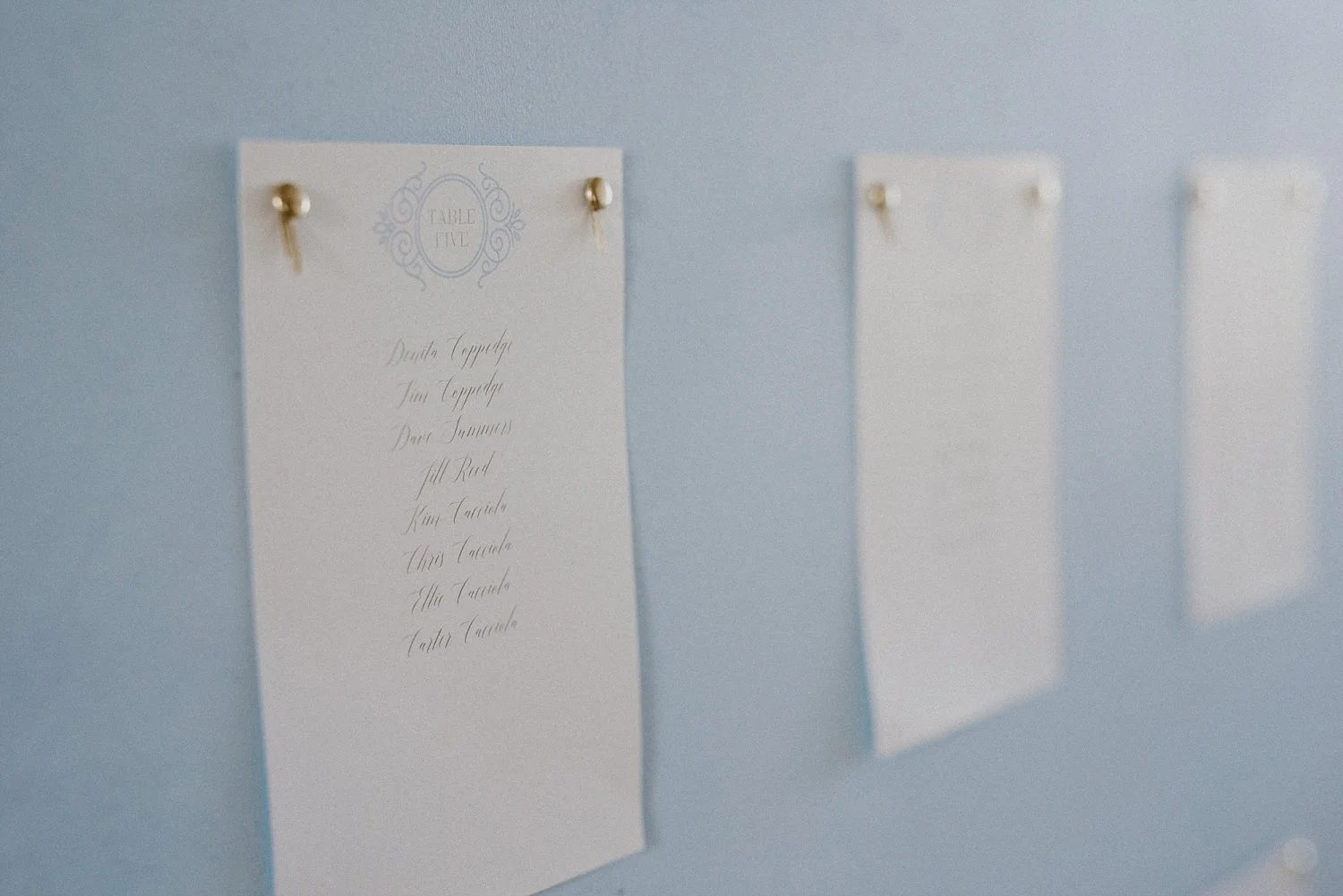 Guest place cards on dusty blue board for White Sparrow Barn wedding