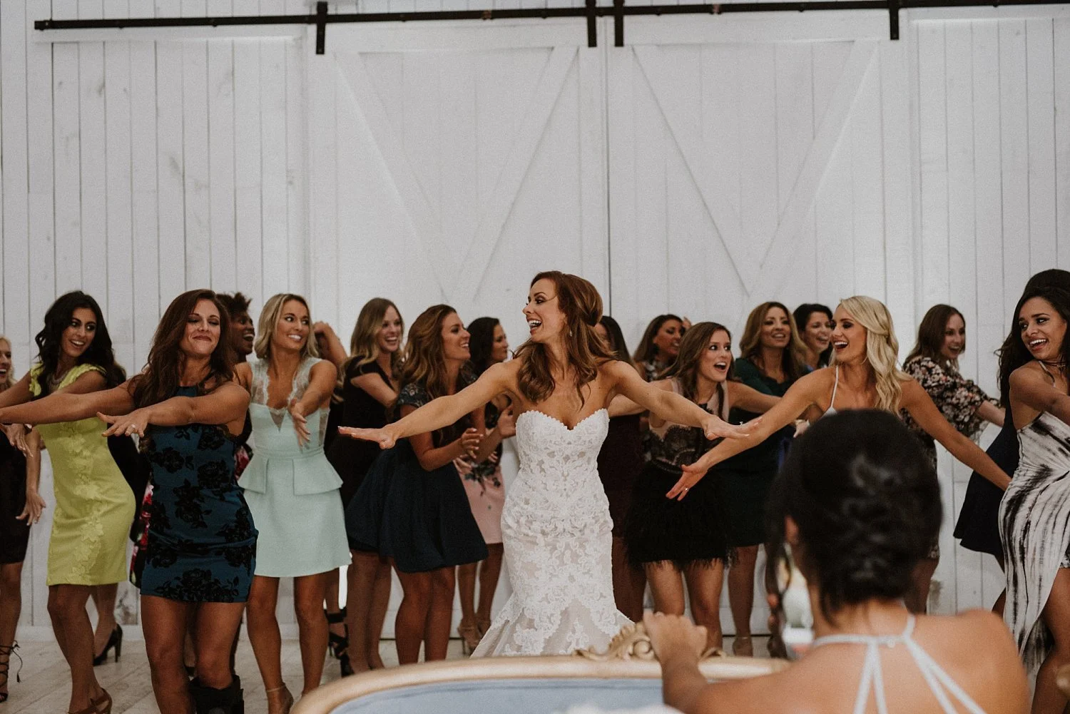 Dallas cowboy cheerleader bride dancing with cheerleaders at white sparrow barn wedding