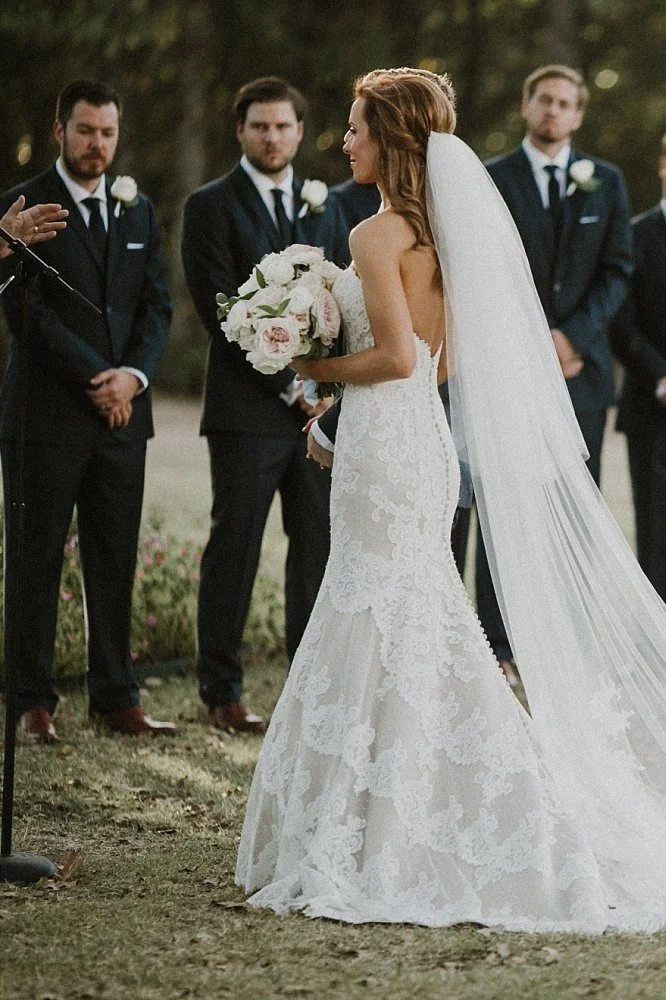 Dallas Cowboy Cheerleader bride at White Sparrow Barn outdoor ceremony with long cathedral veil