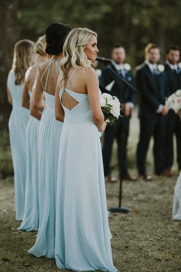 Light blue bridesmaid dresses holding blush flowers