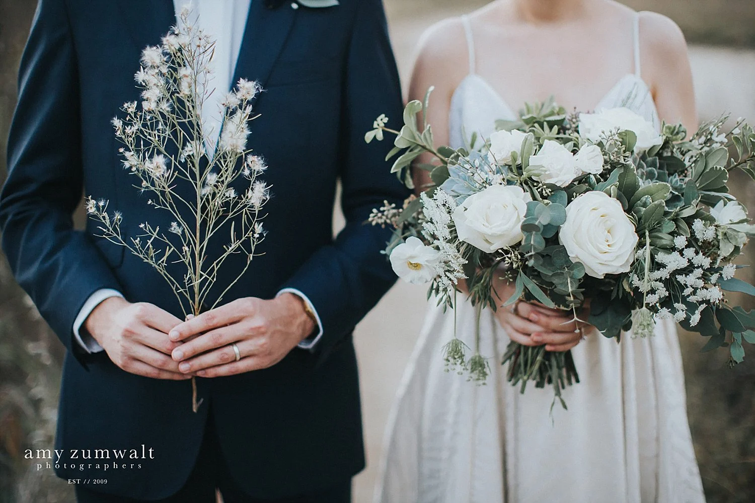 Bride and groom holding greenery