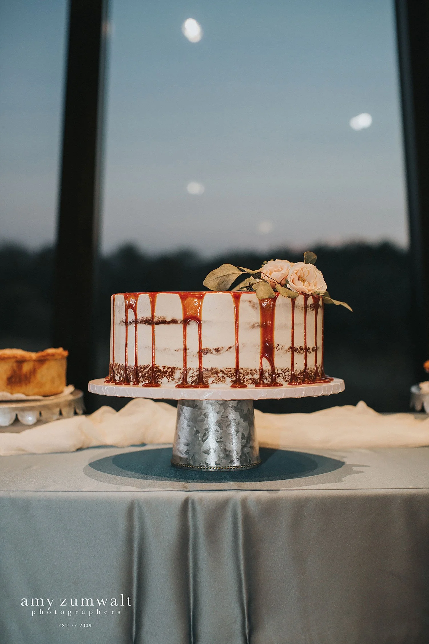 Caramel drip cake with a galvanized metal cake stand