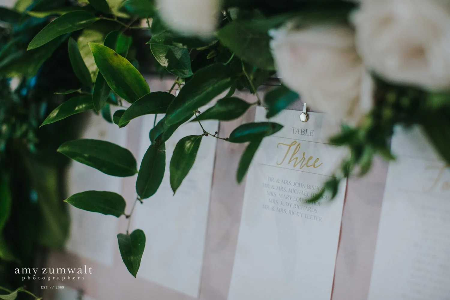 Seating chart with gold writing and white paper