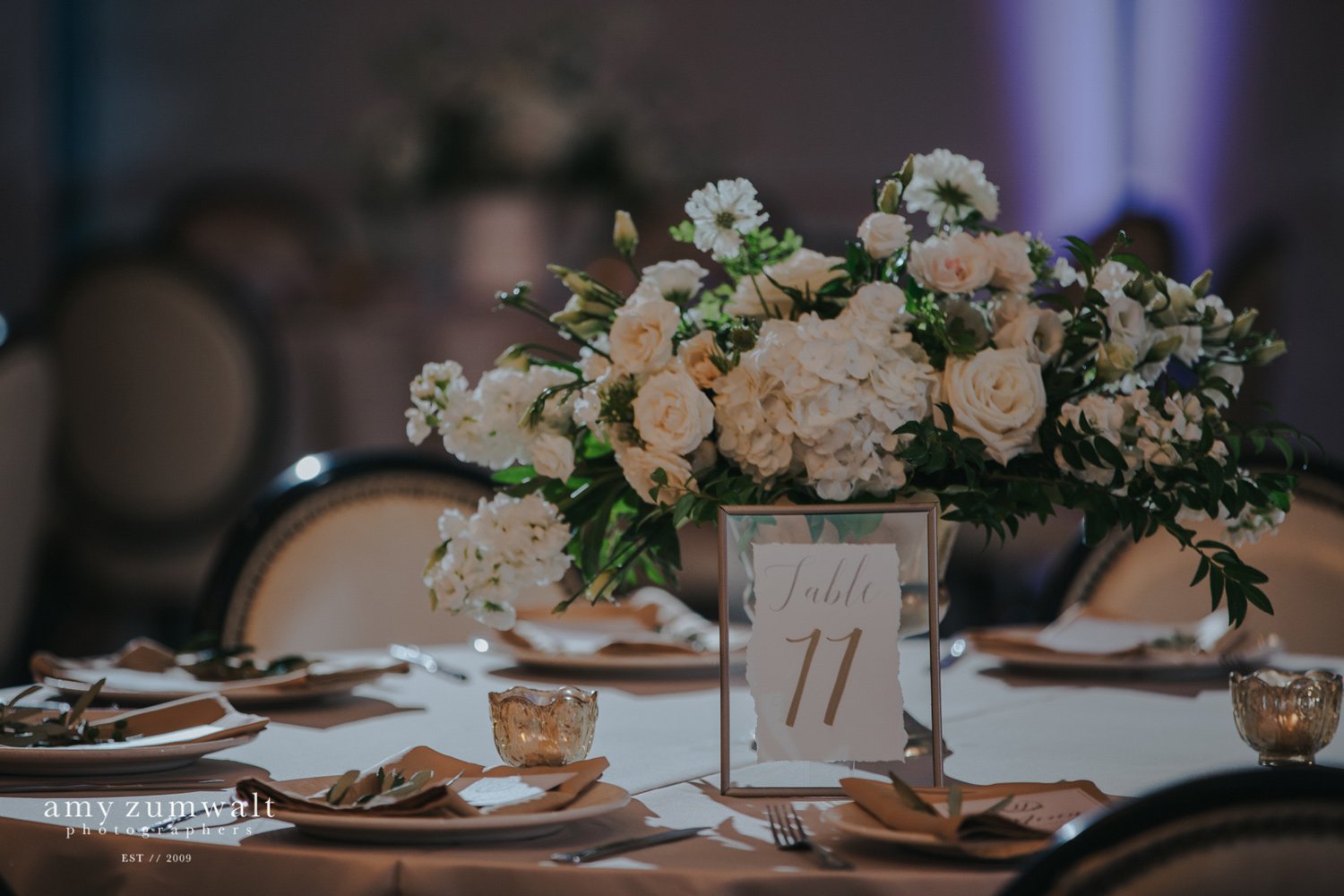 White and green flowers in a gold vase with a float frame table number