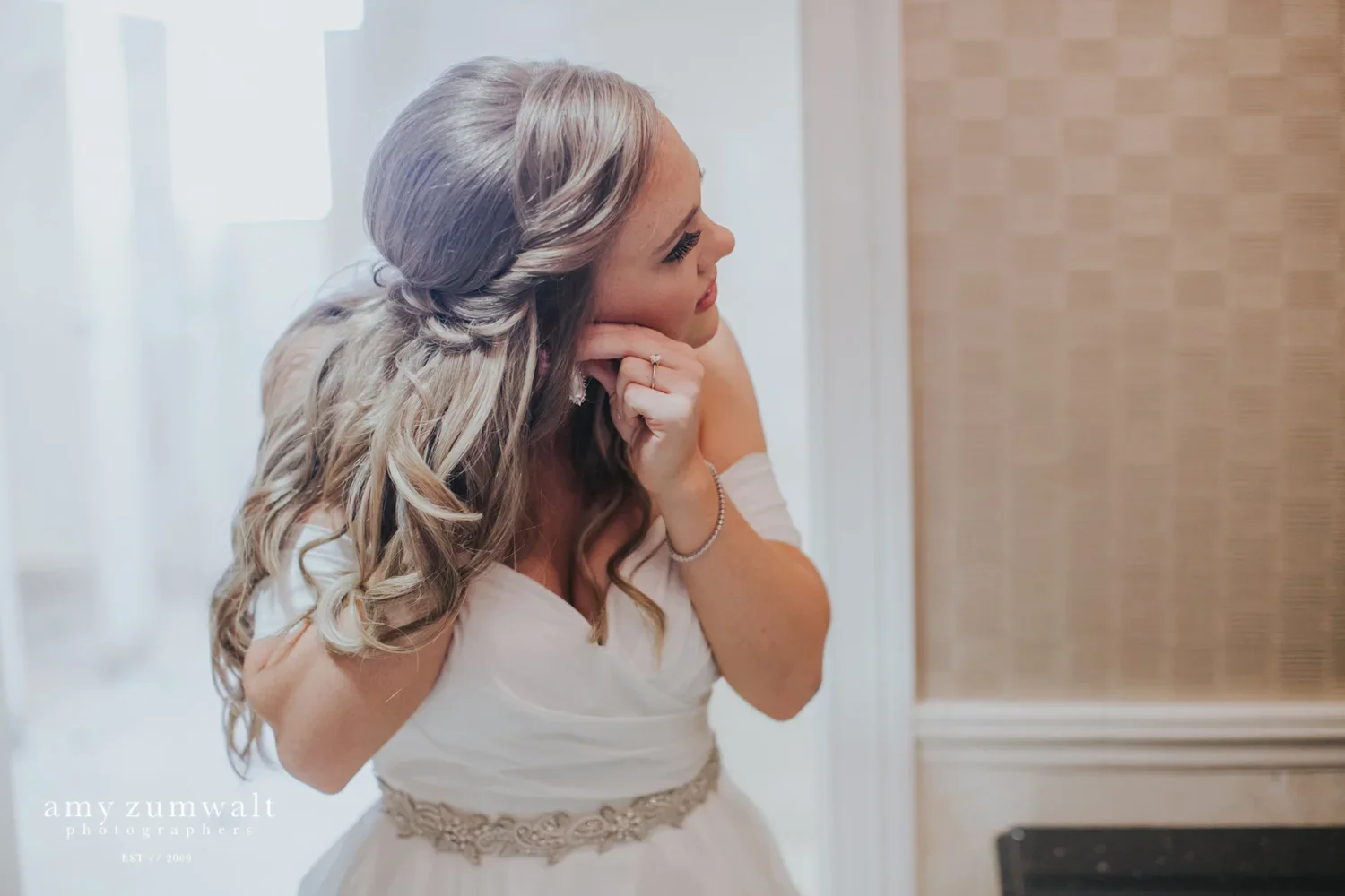 Bride putting on her earrings