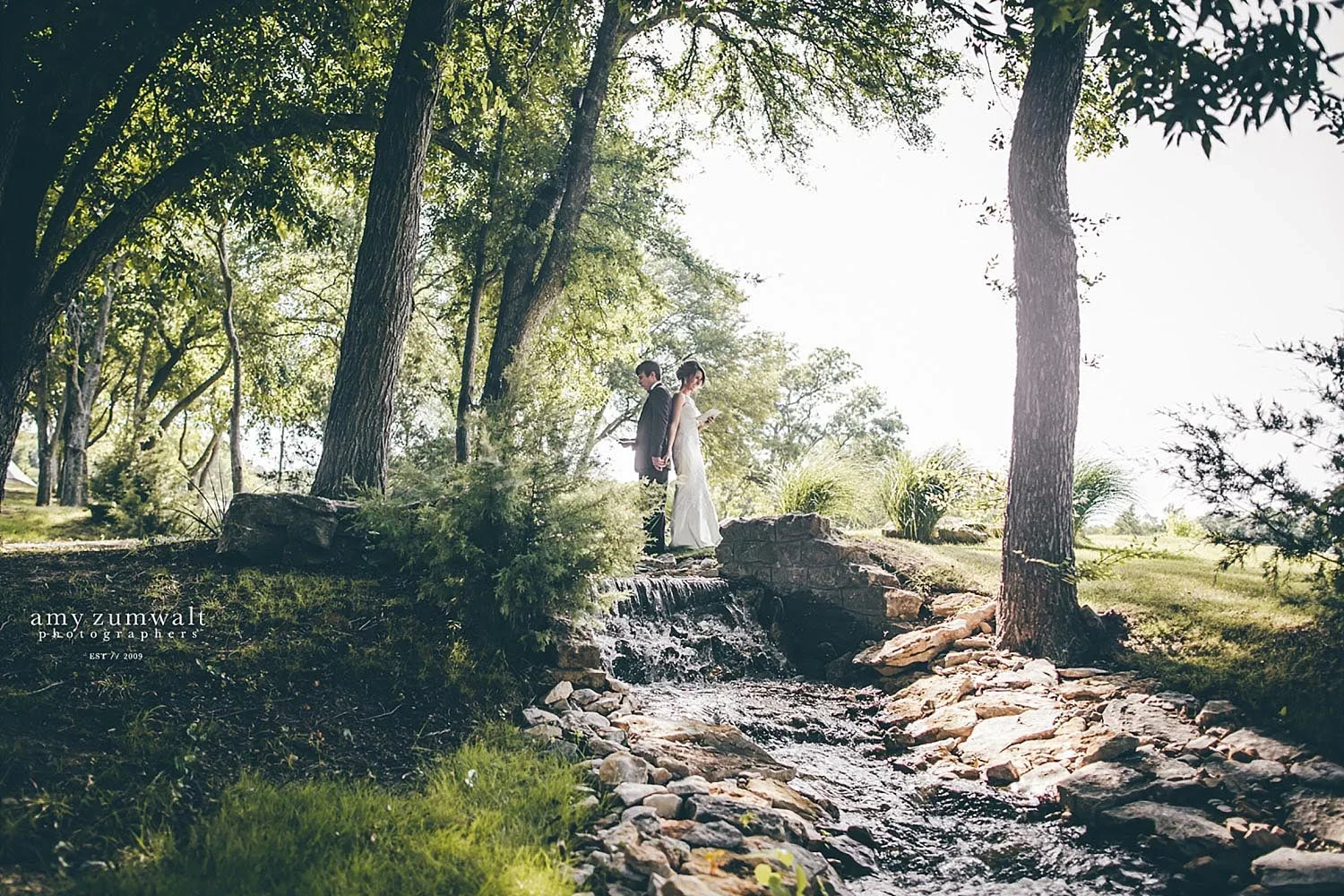 Brooks at Weatherford bride and groom praying on creek bridge