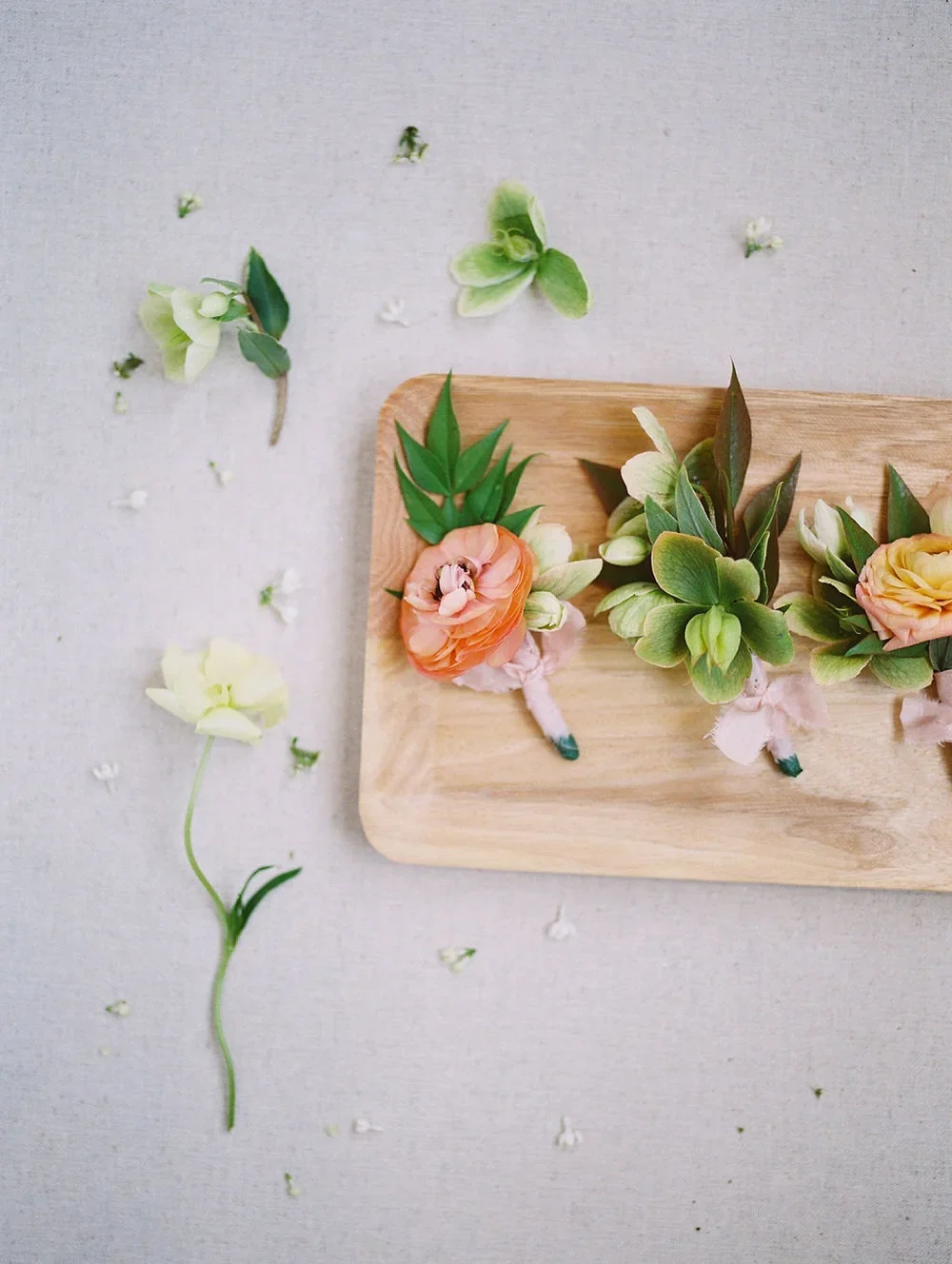 Organic boutonnieres on wood tray